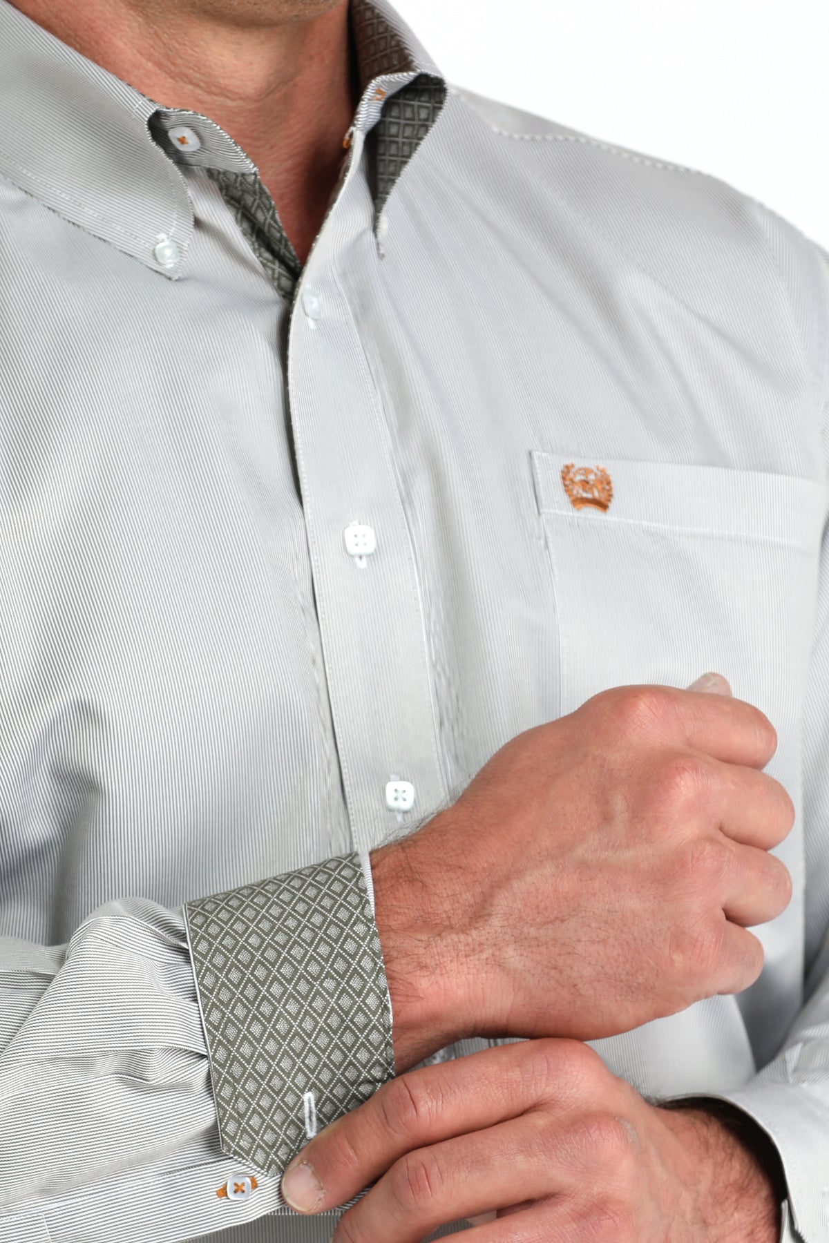 Close-up of a man wearing a white long sleeve button-down with contrasting cuff details