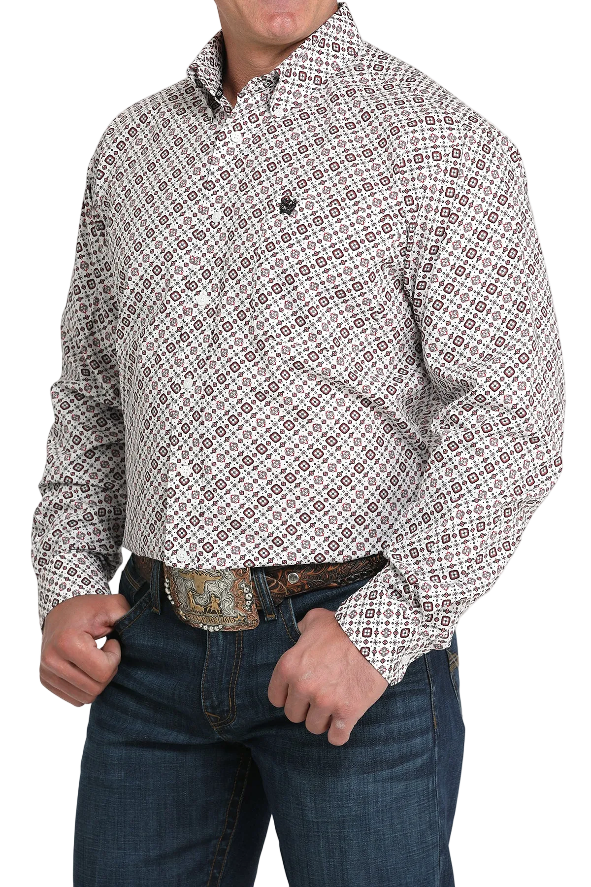 A man wearing a light patterned button-up shirt, dark jeans, and a large belt buckle, standing against a transparent background
