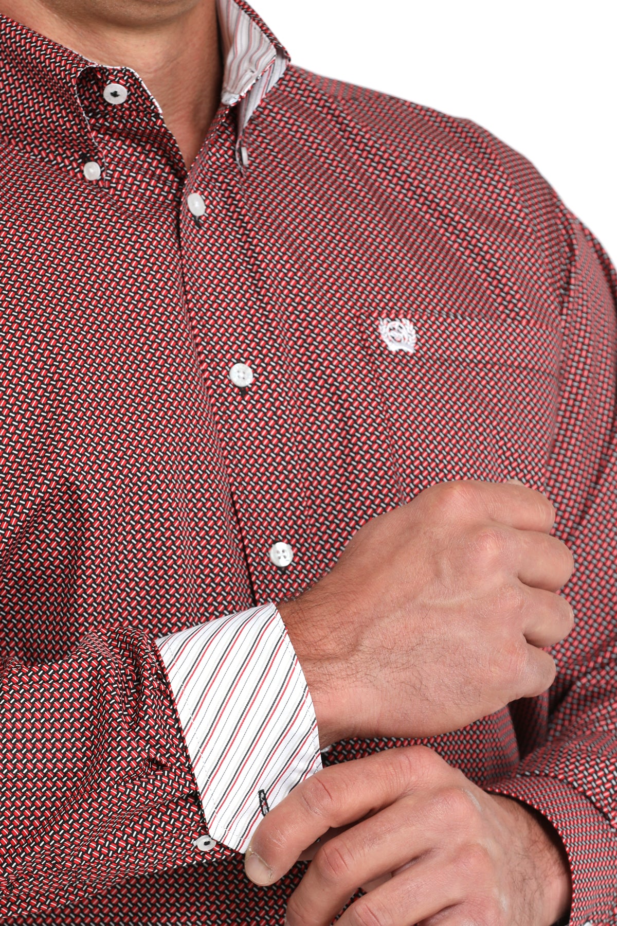 Close-up of a man wearing a maroon, patterned, long sleeve, button-down shirt with contrasting cuffs and a chest pocket