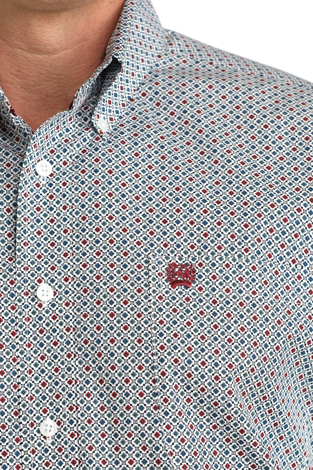 Close-up of a patterned shirt with a brand logo on a white background