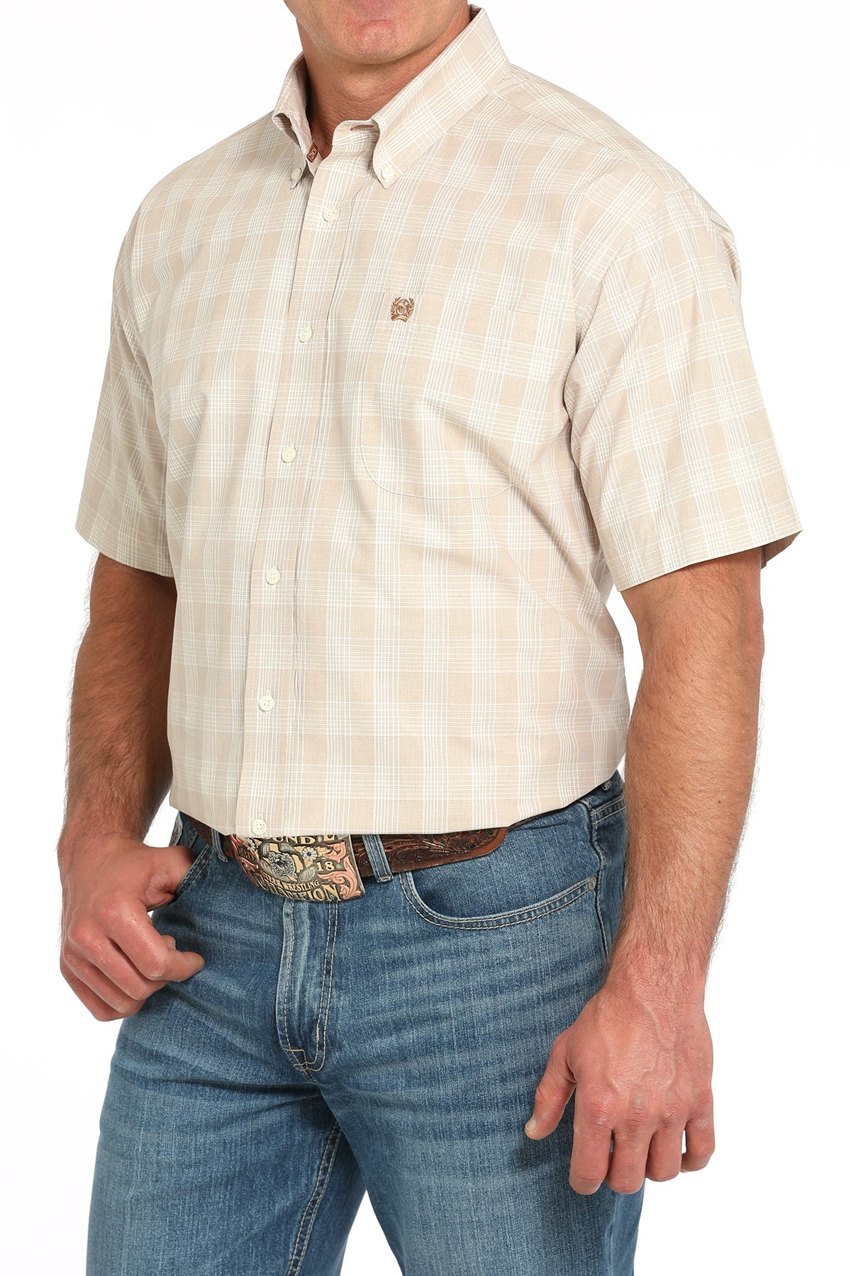 Man wearing a beige short-sleeve shirt and blue jeans on a white background