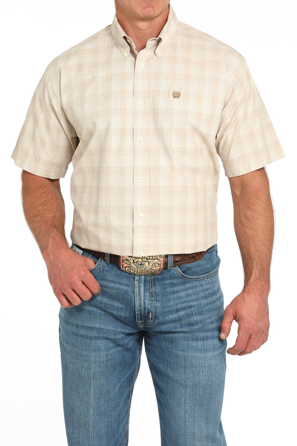 Man wearing a beige short-sleeve shirt and blue jeans on a white background