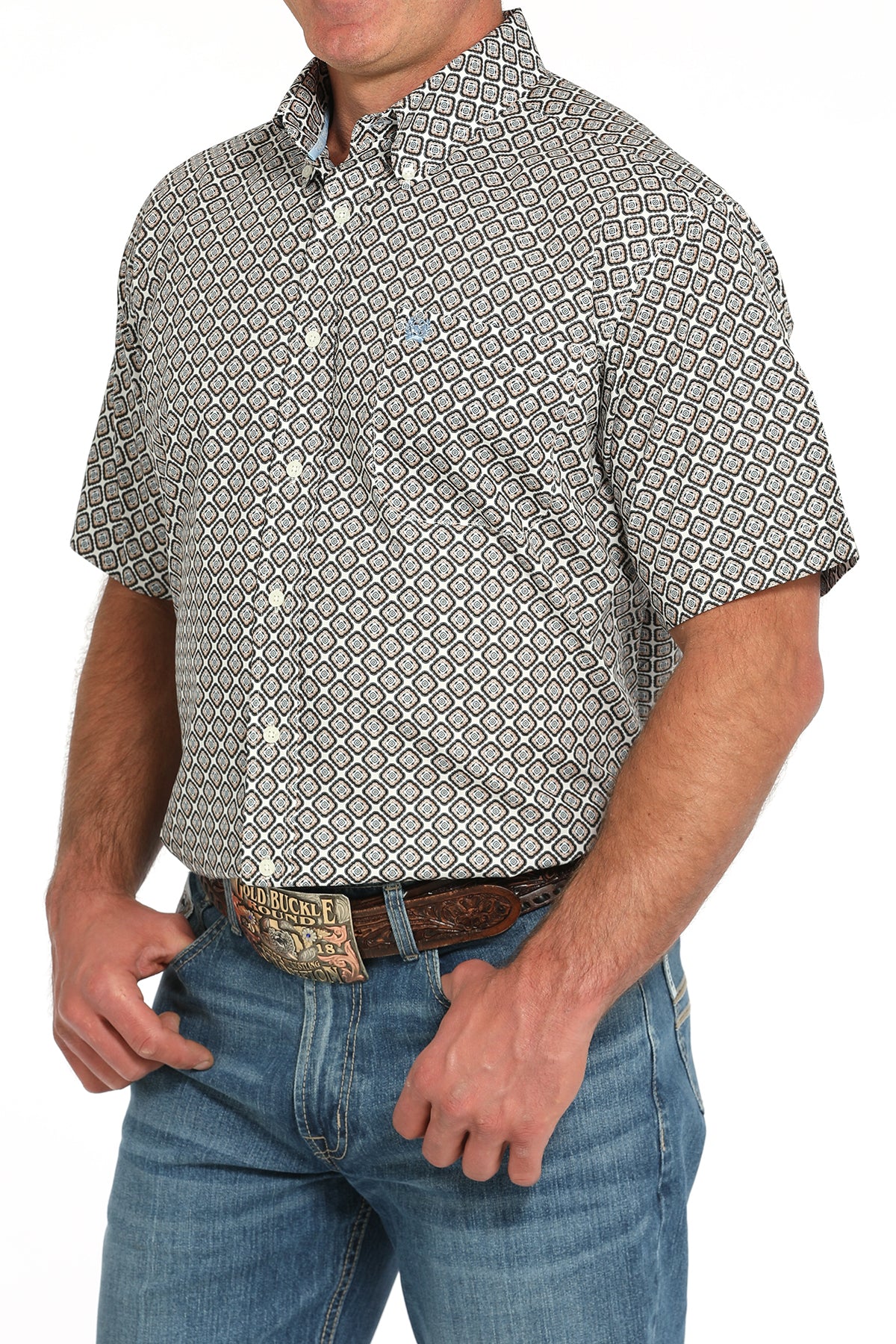 Man wearing a patterned short sleeve button-down with jeans and a belt