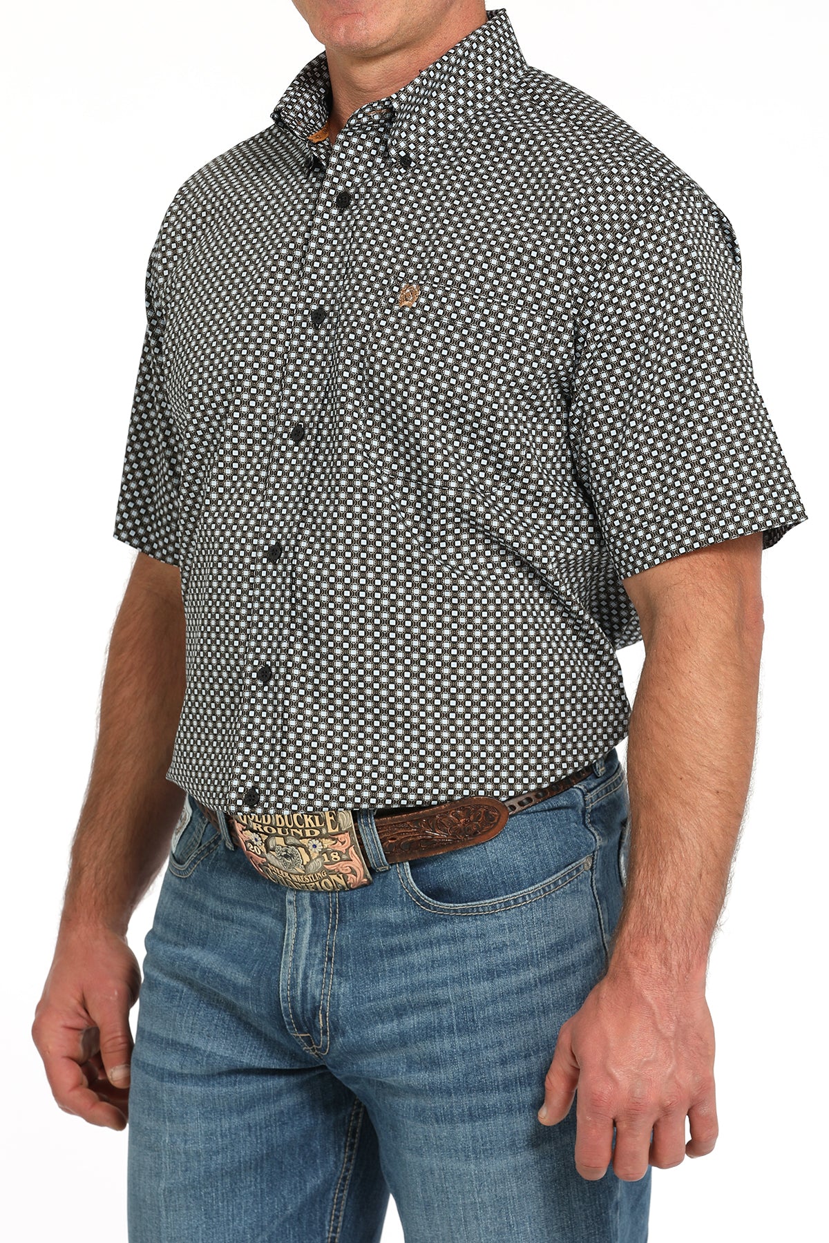 Man wearing a patterned short-sleeve shirt and jeans on a white background