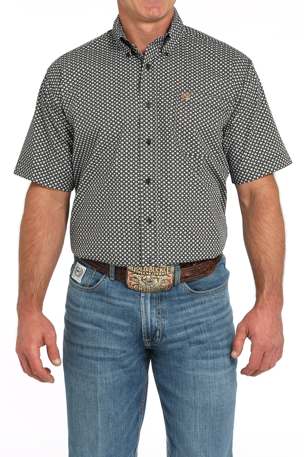 Man wearing a patterned short-sleeve shirt and jeans on a white background