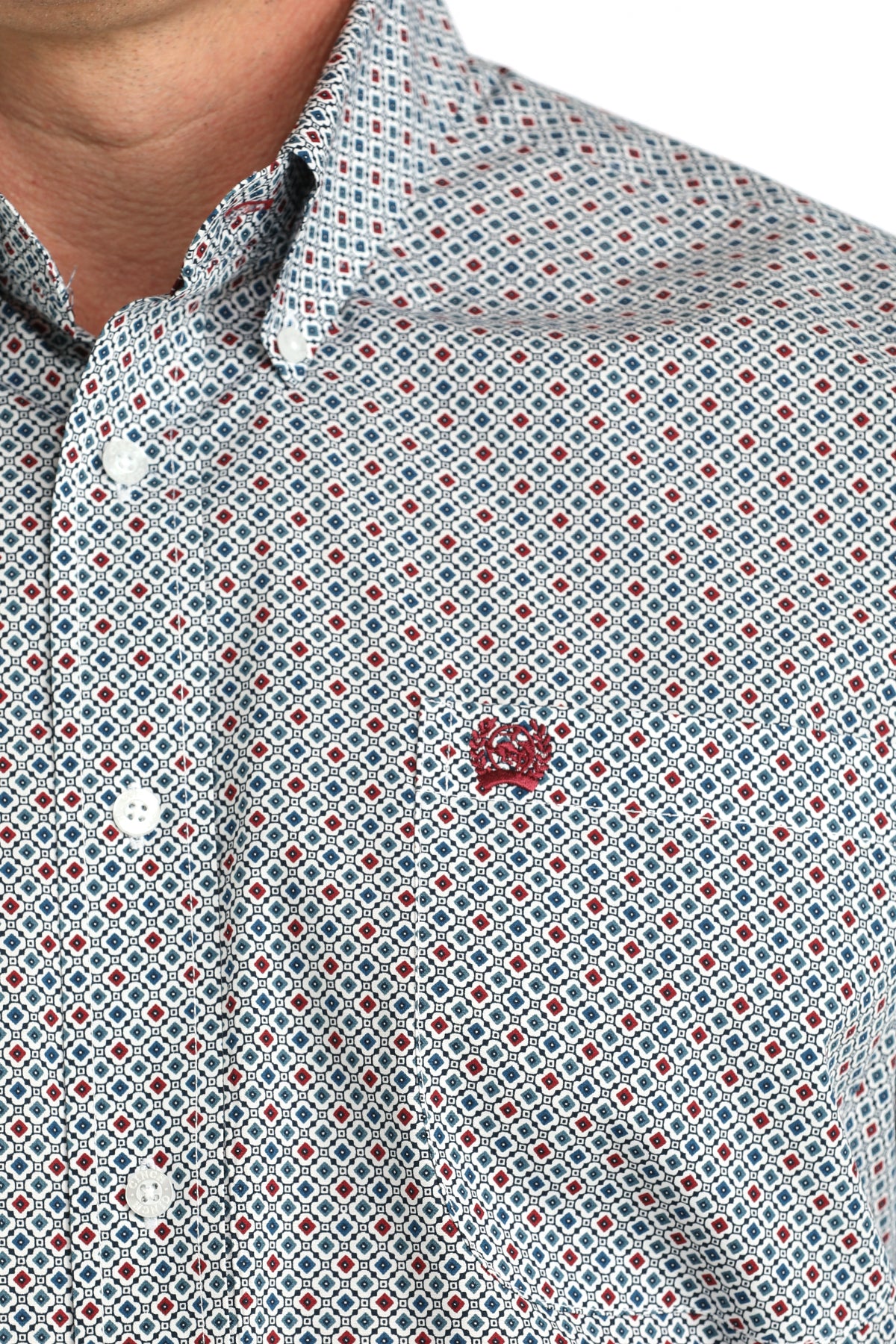 Close-up of a patterned shirt with a small logo on a white background