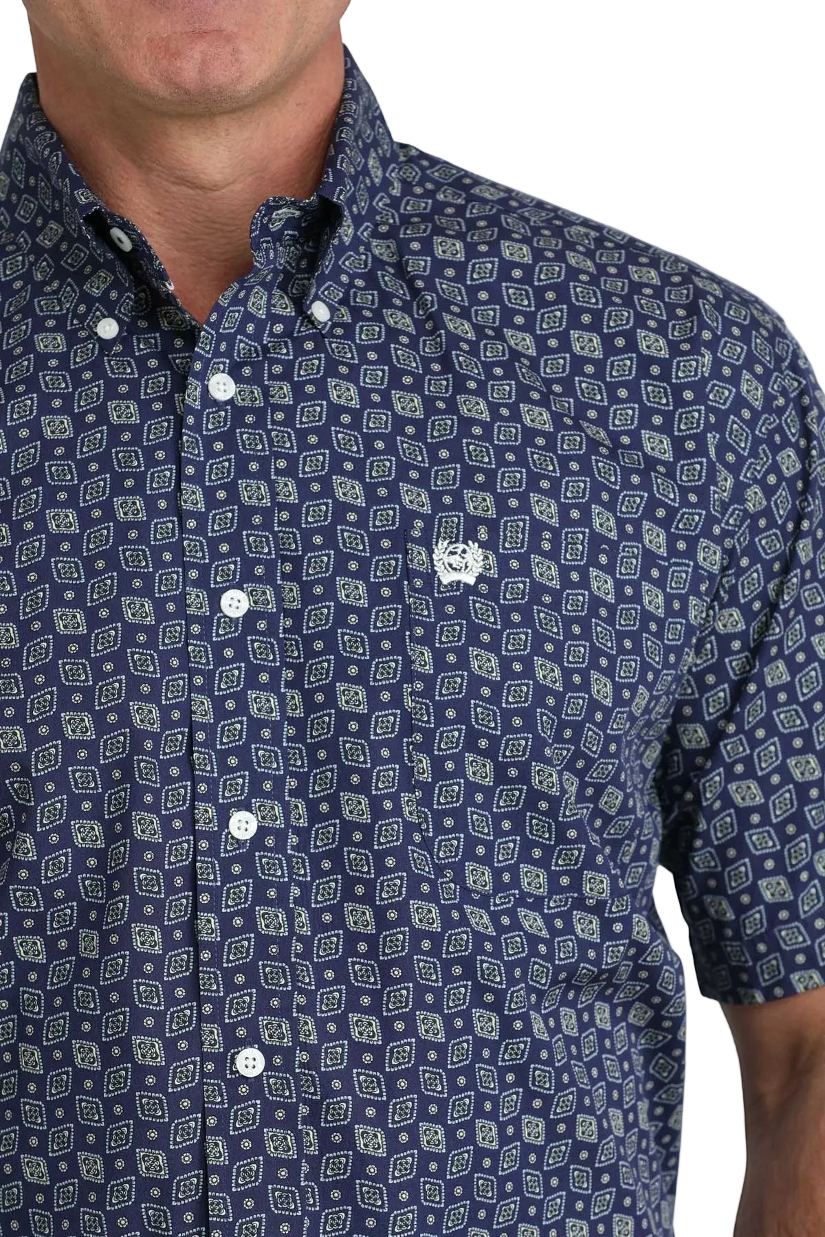 Man wearing a navy blue patterned shirt with a white background