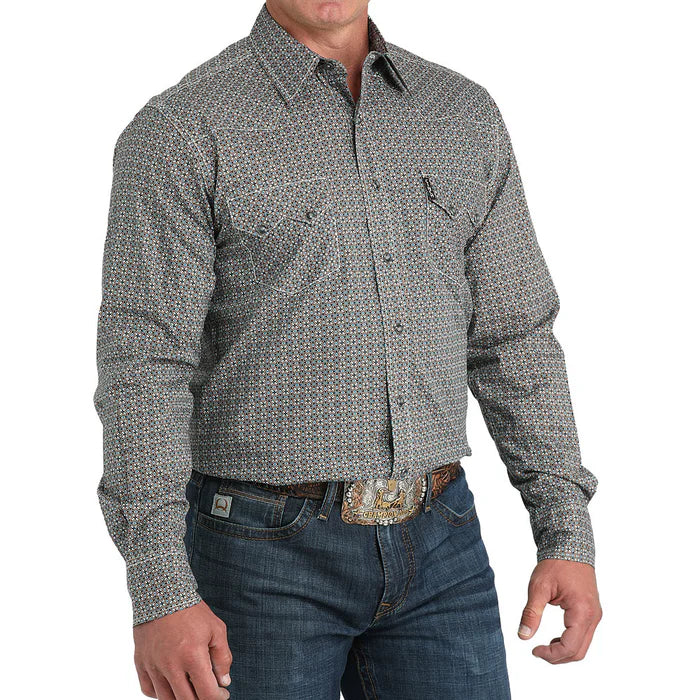 Man wearing a patterned long-sleeve shirt and jeans on a white background