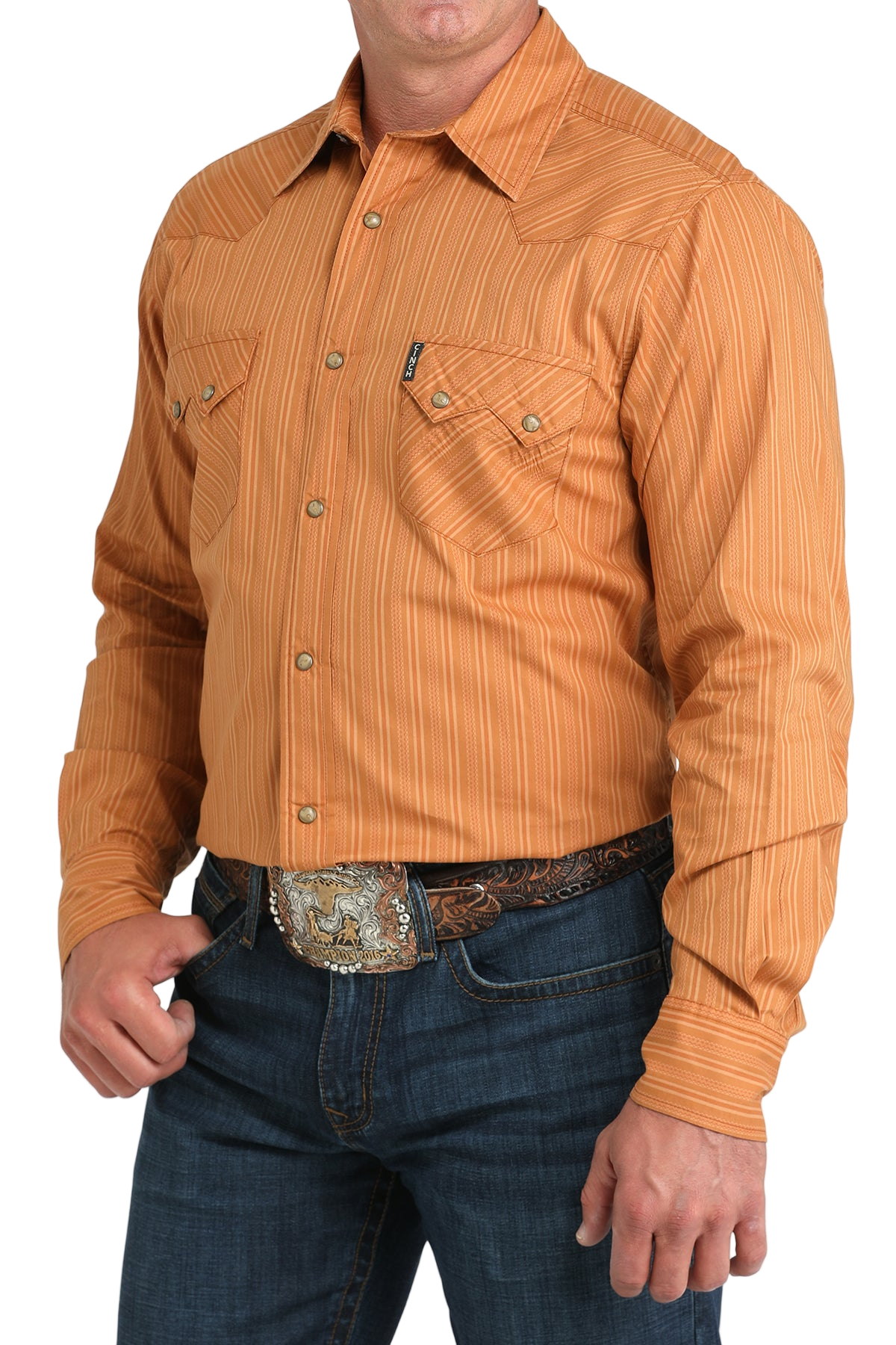 Man wearing a orange button-up shirt with blue jeans on a white background