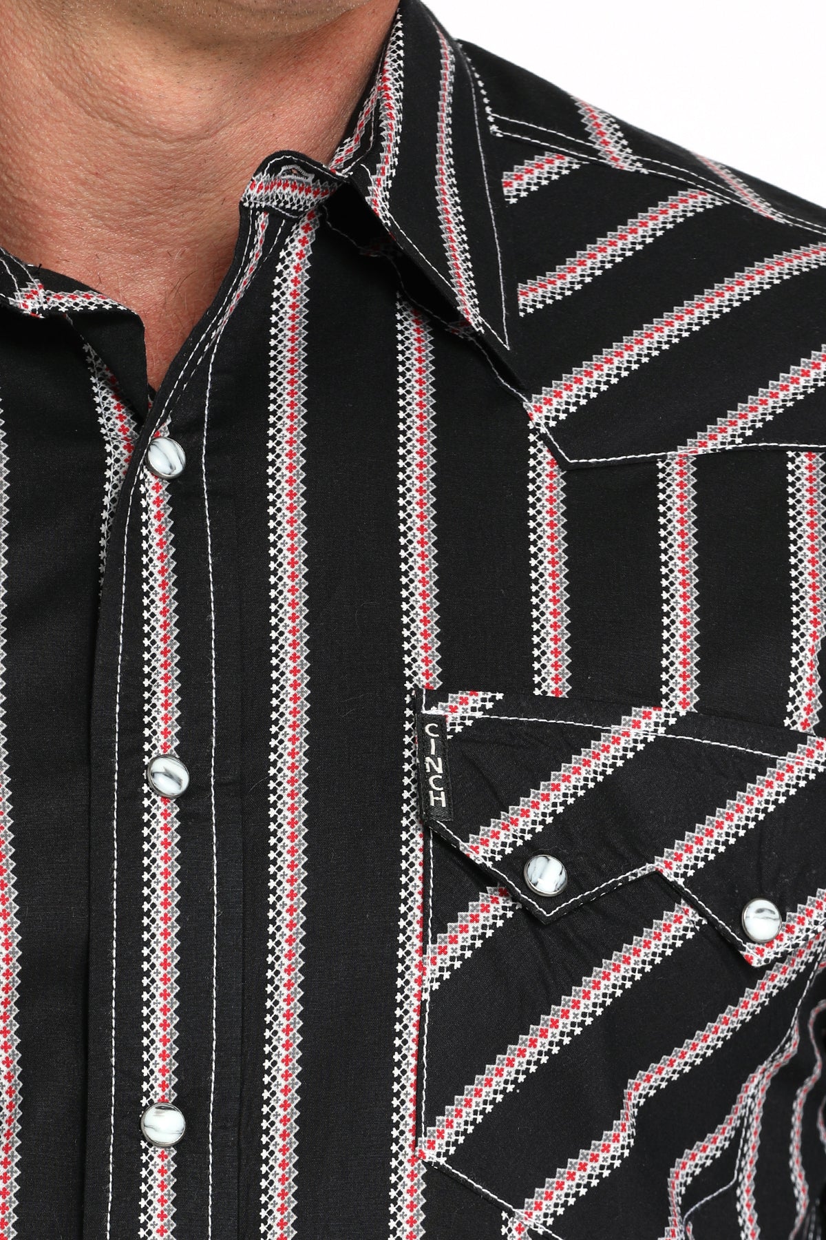 Close-up of a man wearing a black striped button-up shirt with a chest pocket, displayed against a white background