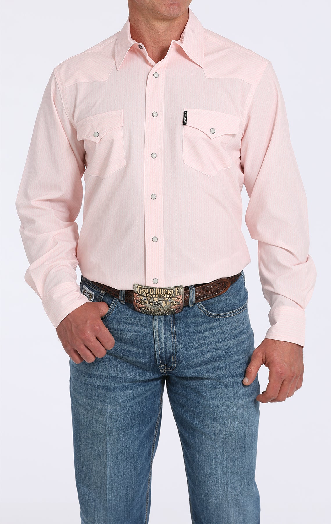 Person wearing a light pink button-up shirt and blue jeans on a white background