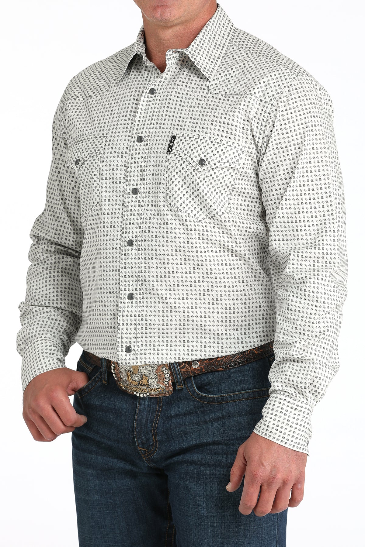 Man wearing a patterned long-sleeve shirt and jeans on a white background