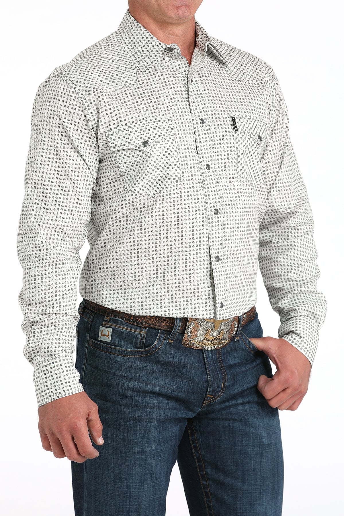 Man wearing a white patterned shirt and blue jeans on a white background