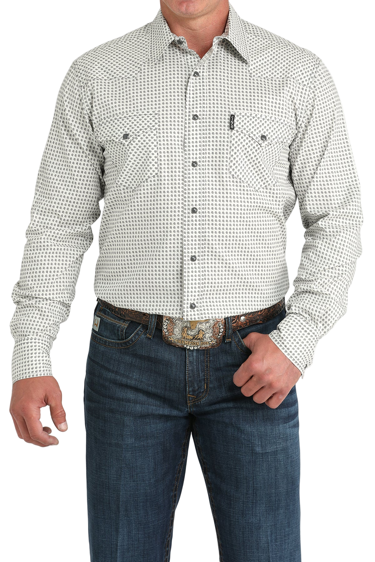 Man wearing a light gray patterned button-up shirt with blue jeans on a white background