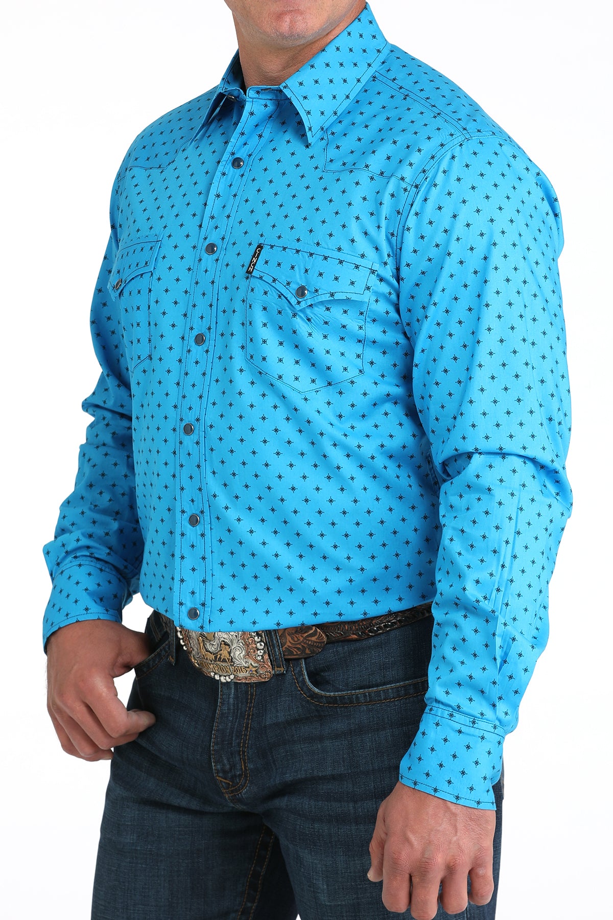 Man wearing a blue patterned shirt and jeans on a white background