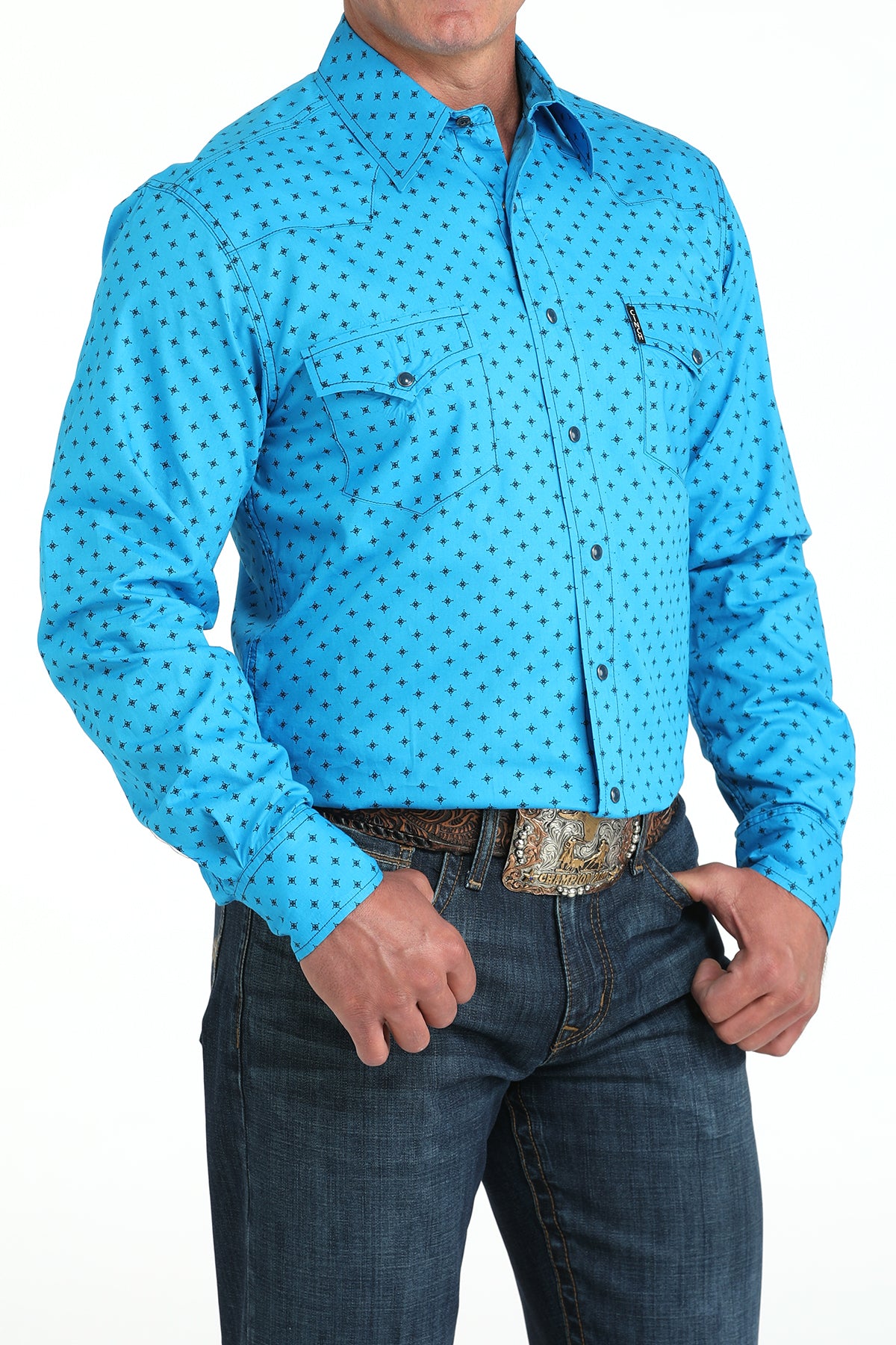 Man wearing a blue patterned shirt and jeans on a white background