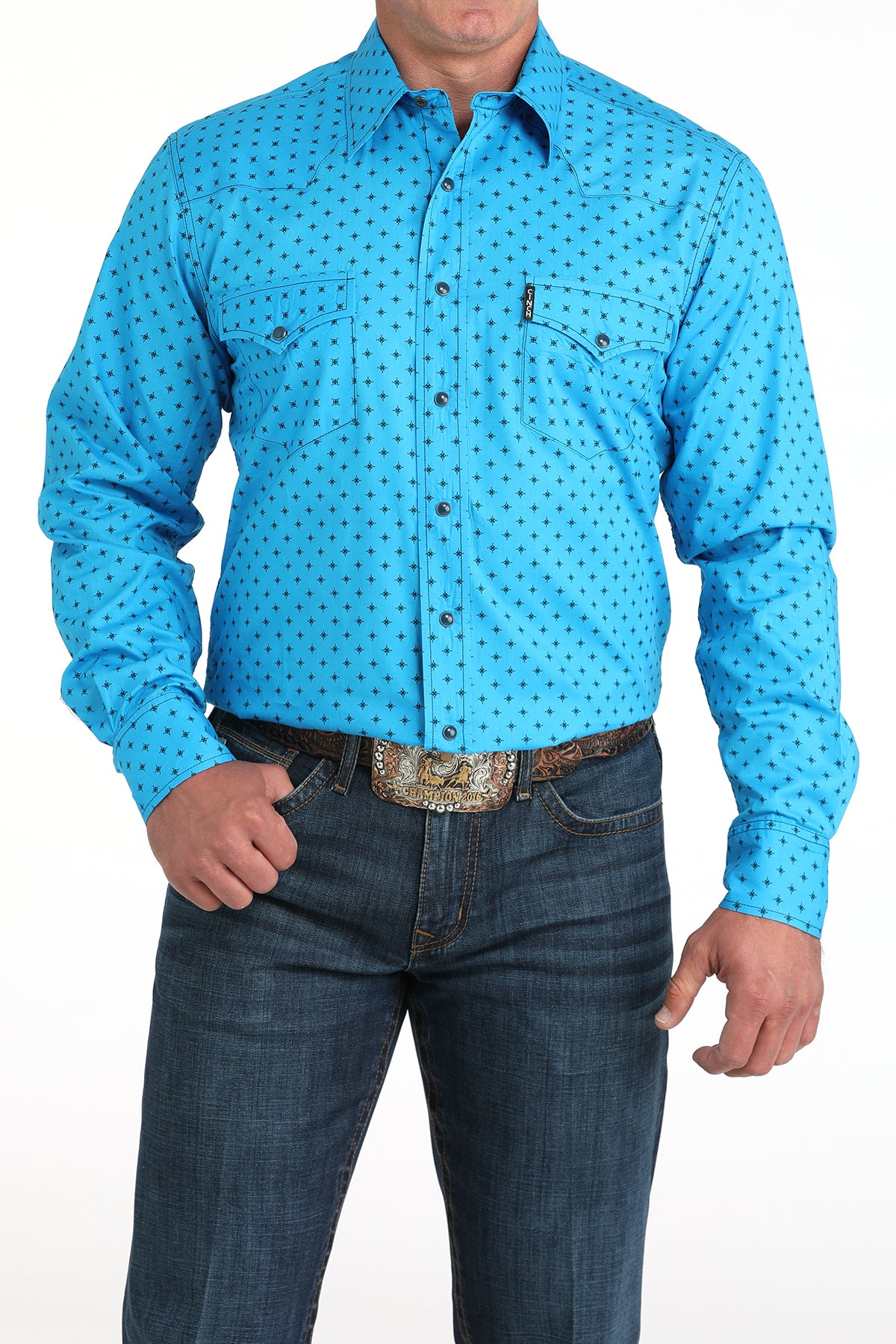 Man wearing a blue patterned shirt and jeans on a white background