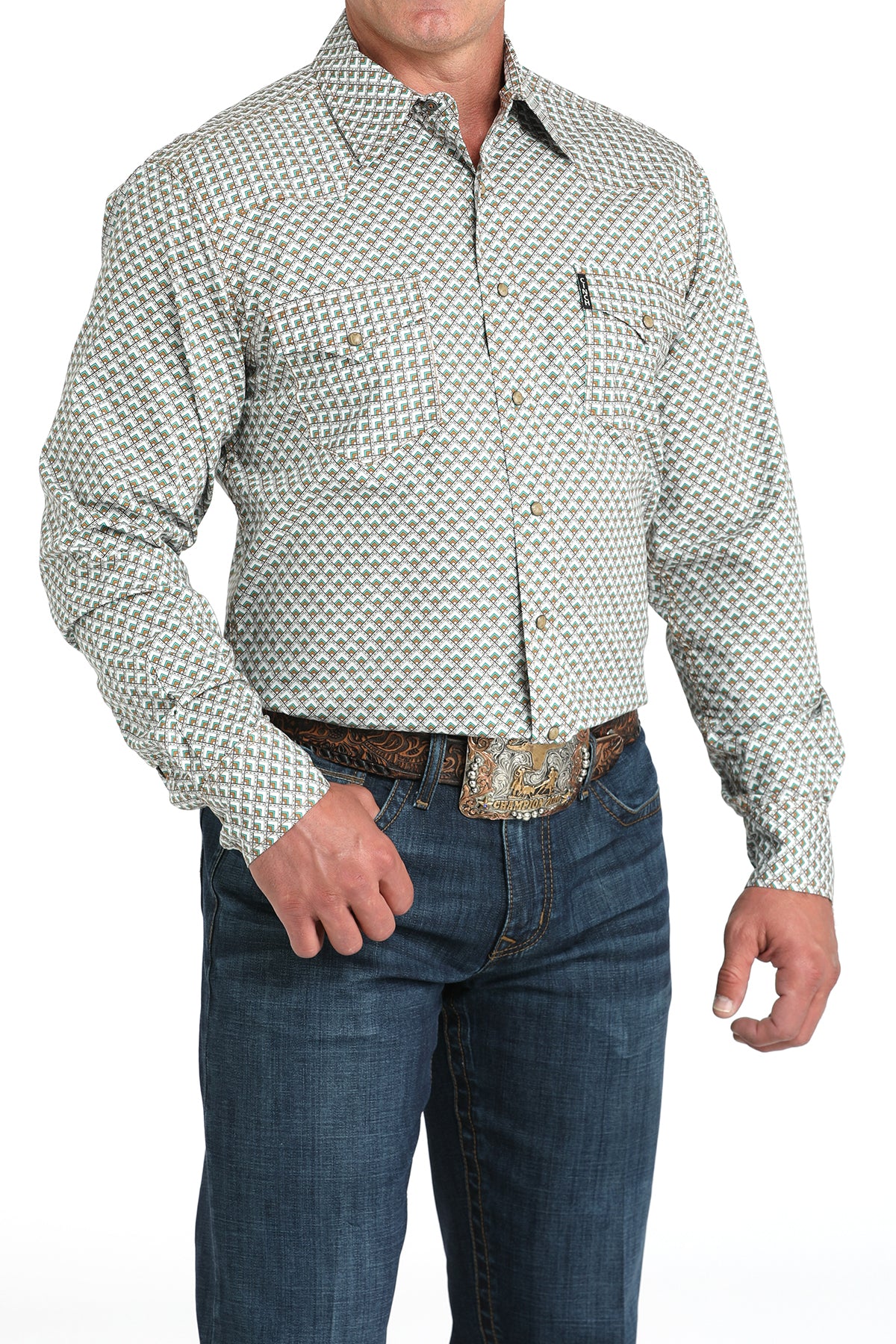Man wearing a long sleeve button-down shirt in white, with jeans and a belt