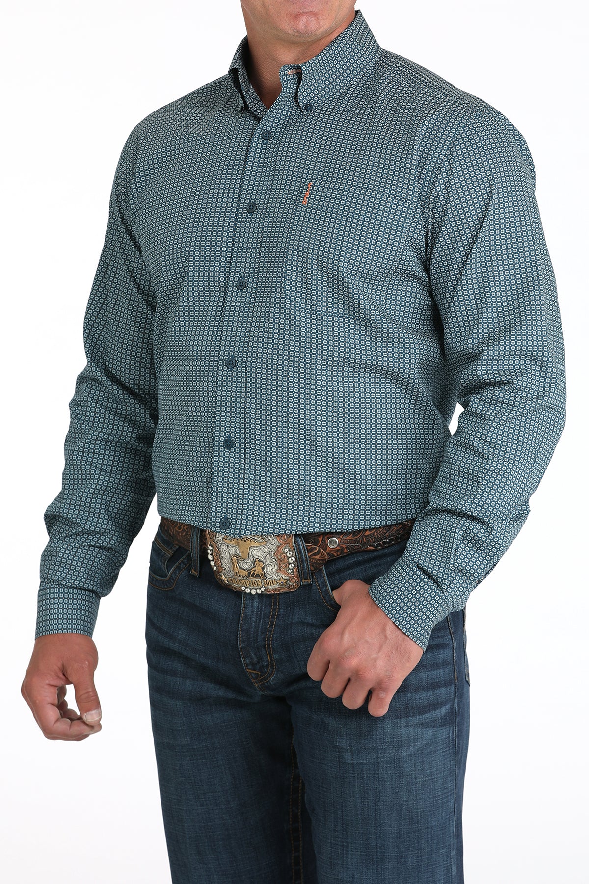 Man wearing a patterned teal shirt and jeans on a white background