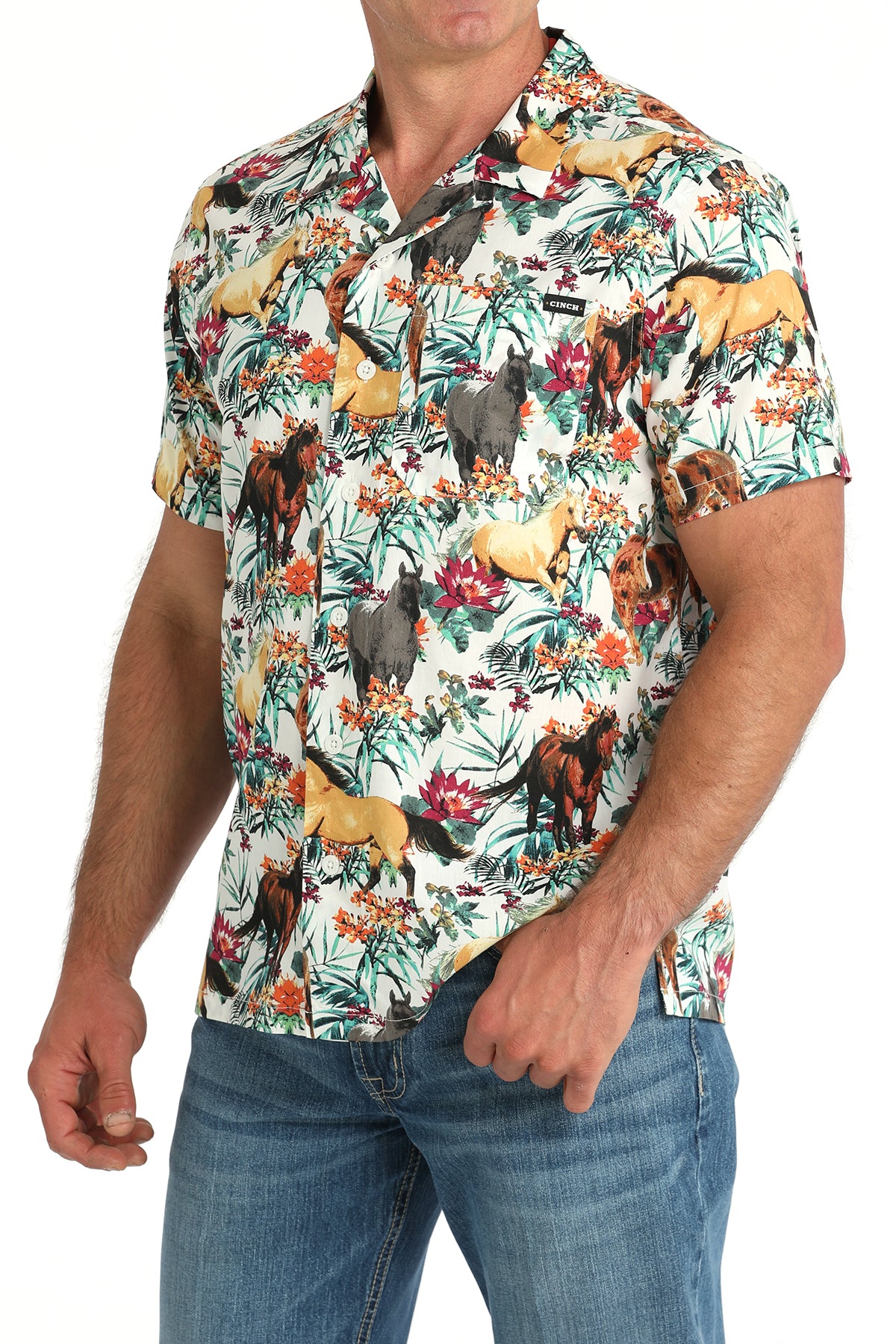 Man wearing a floral shirt with animals on it with jeans and a belt