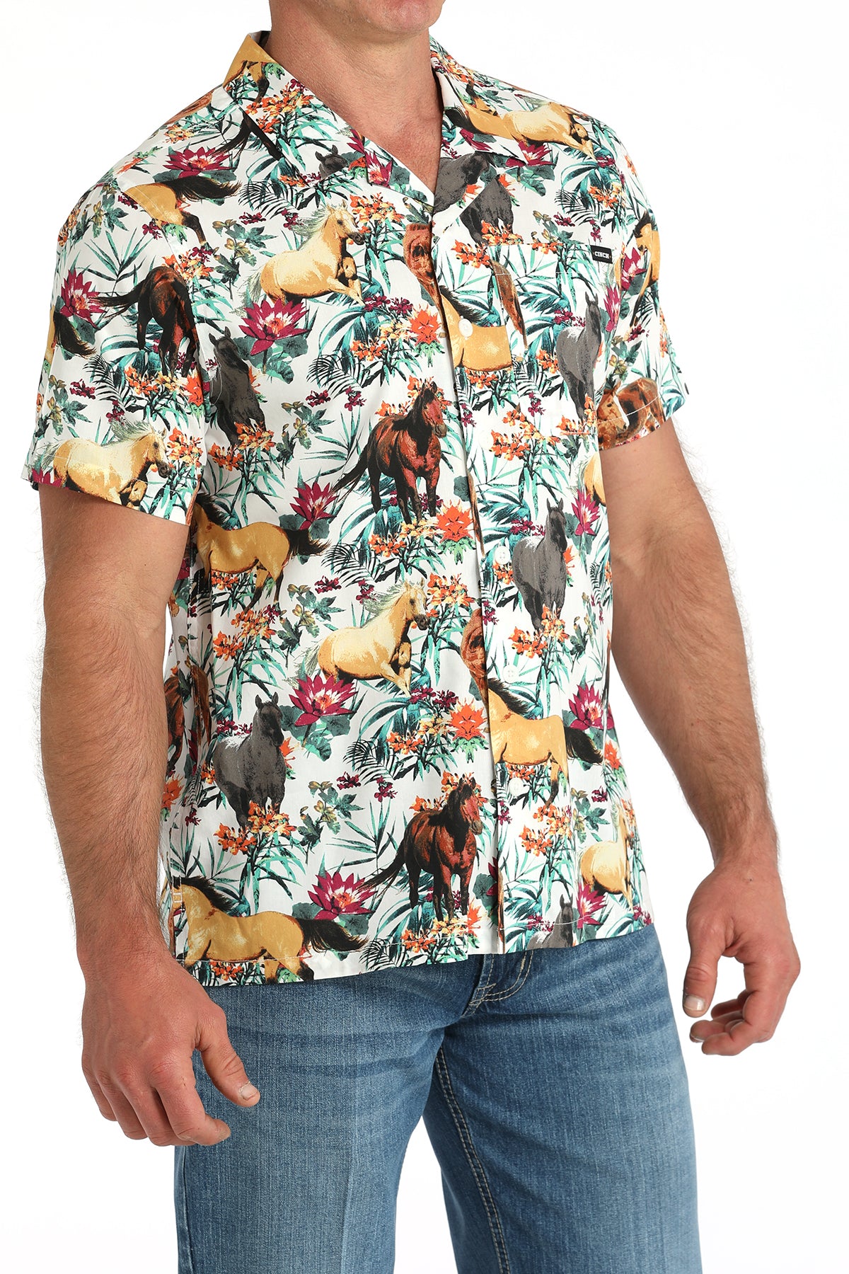Man wearing a floral shirt with animals on it with jeans and a belt