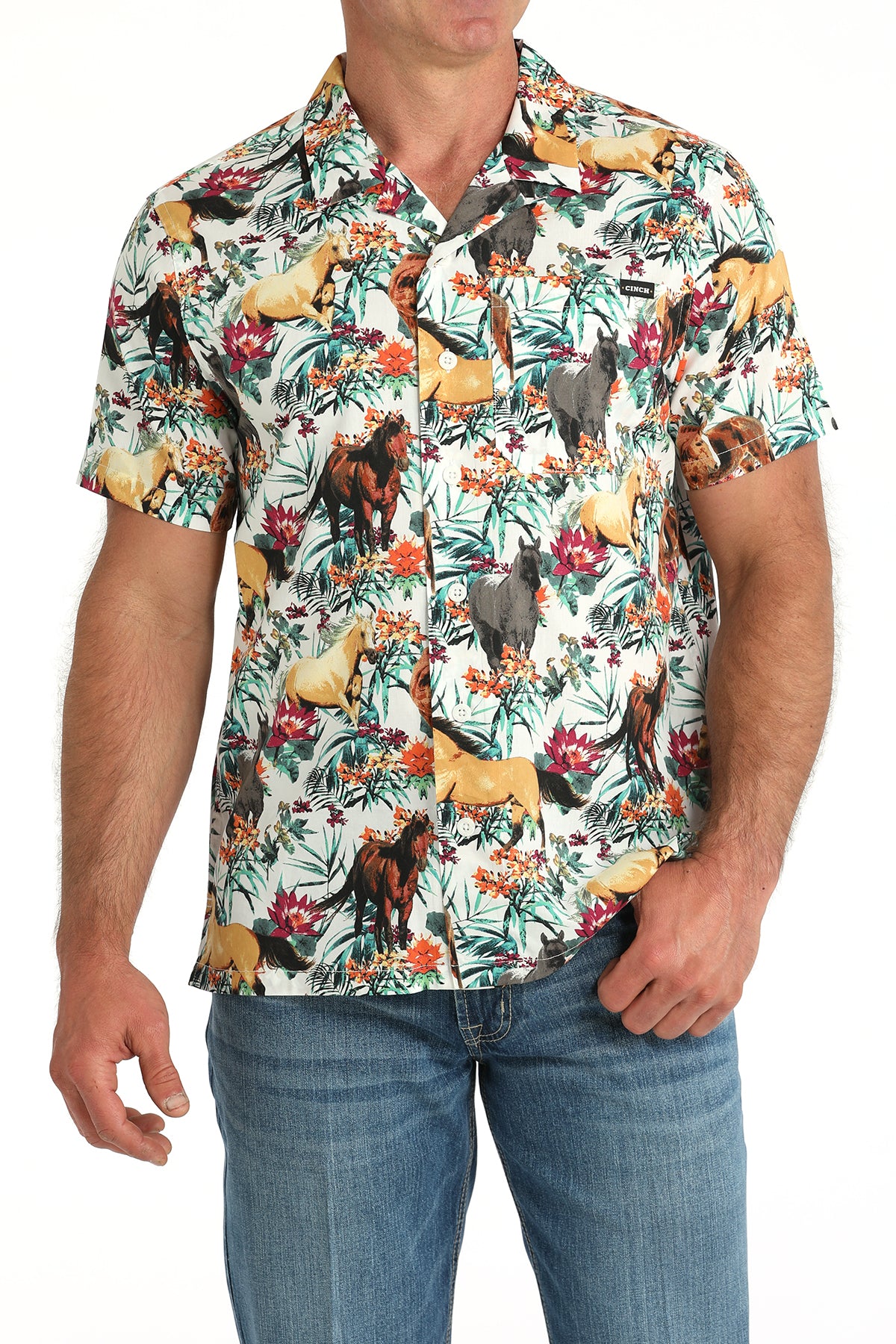 Man wearing a floral shirt with animals on it with jeans and a belt