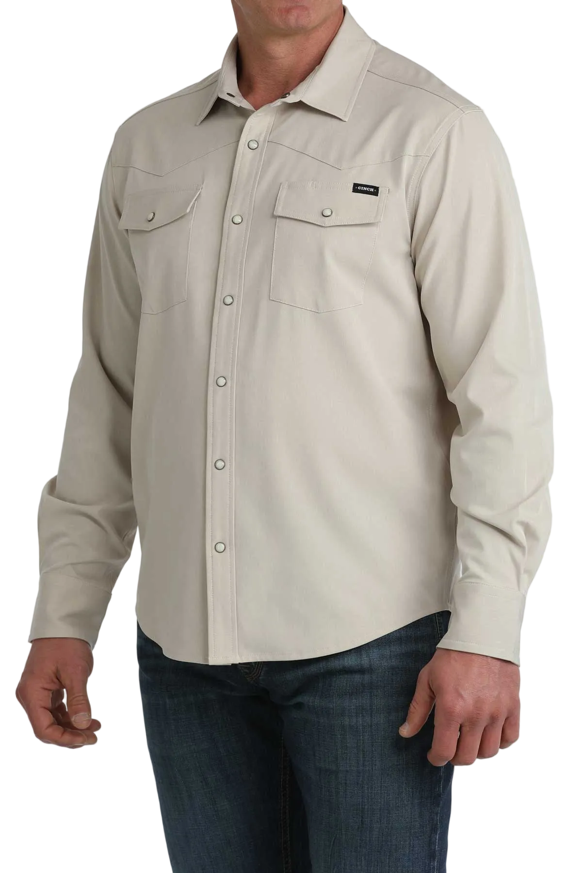 Beige button-up shirt worn by a person on a white background