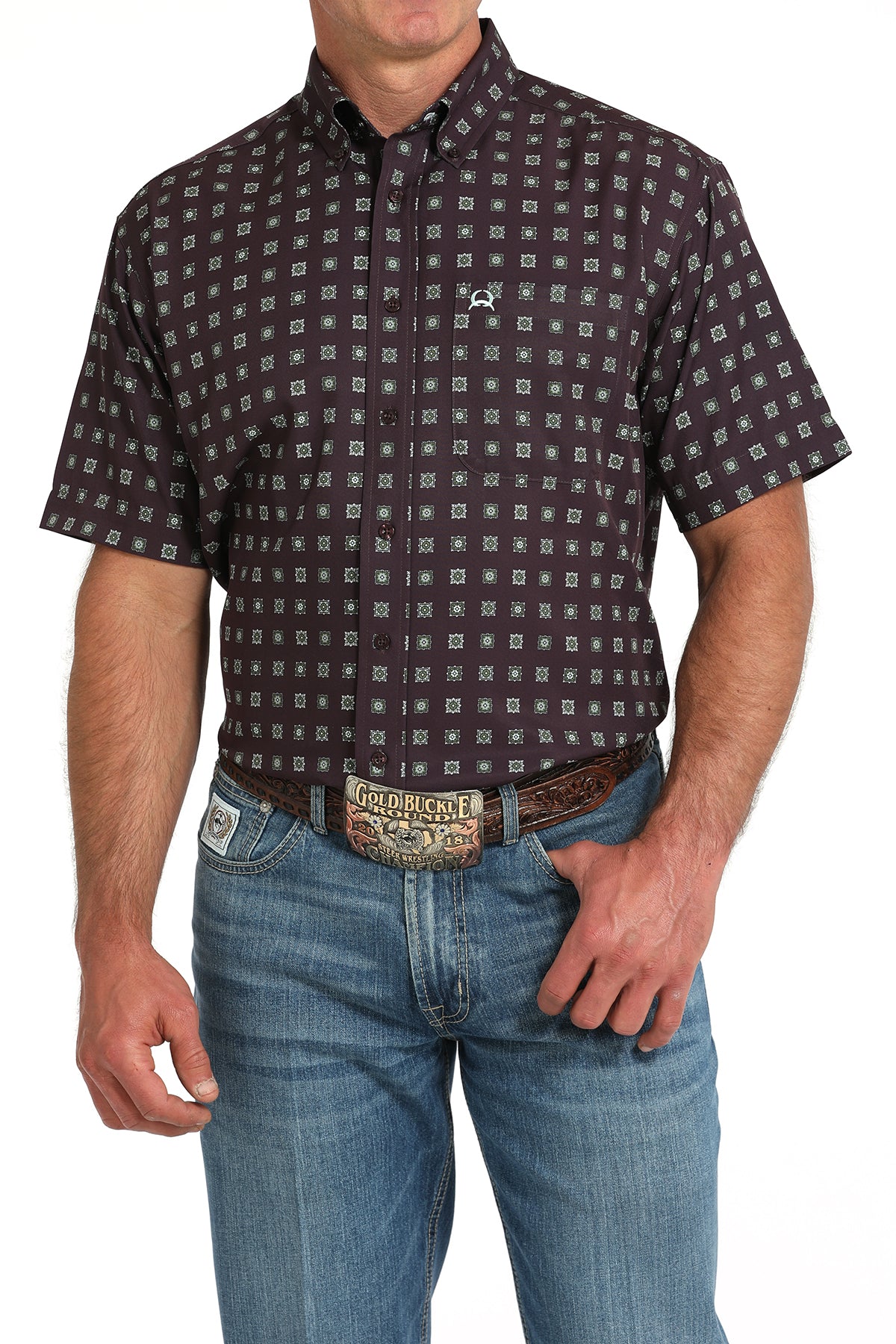 Man wearing a maroon short-sleeve button-down shirt with a geometric print and light blue jeans on a white background