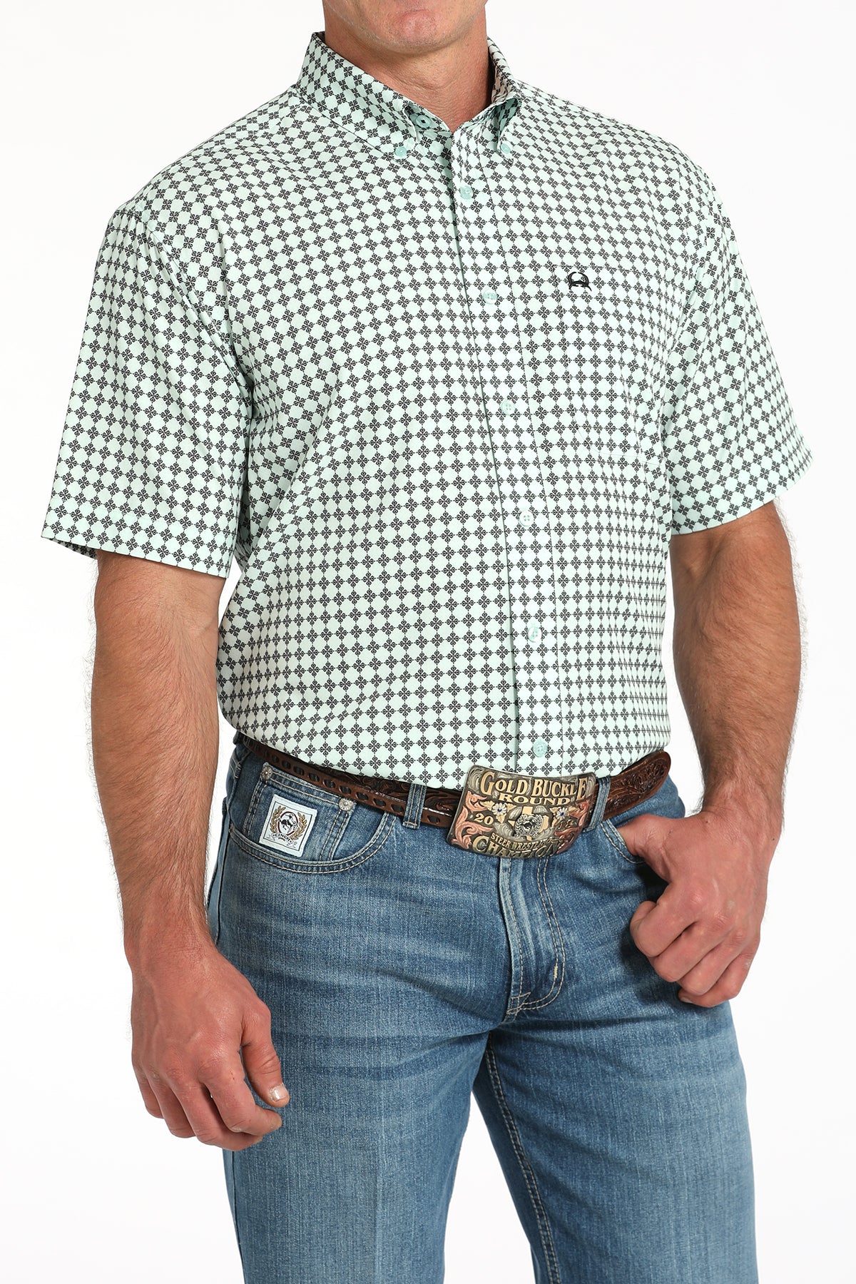 Man wearing a green and white checkered shirt with blue jeans on a white background