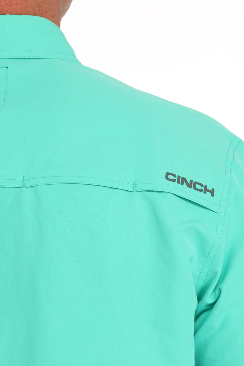 Close-up of a teal shirt with 'CINCH' logo on the chest.