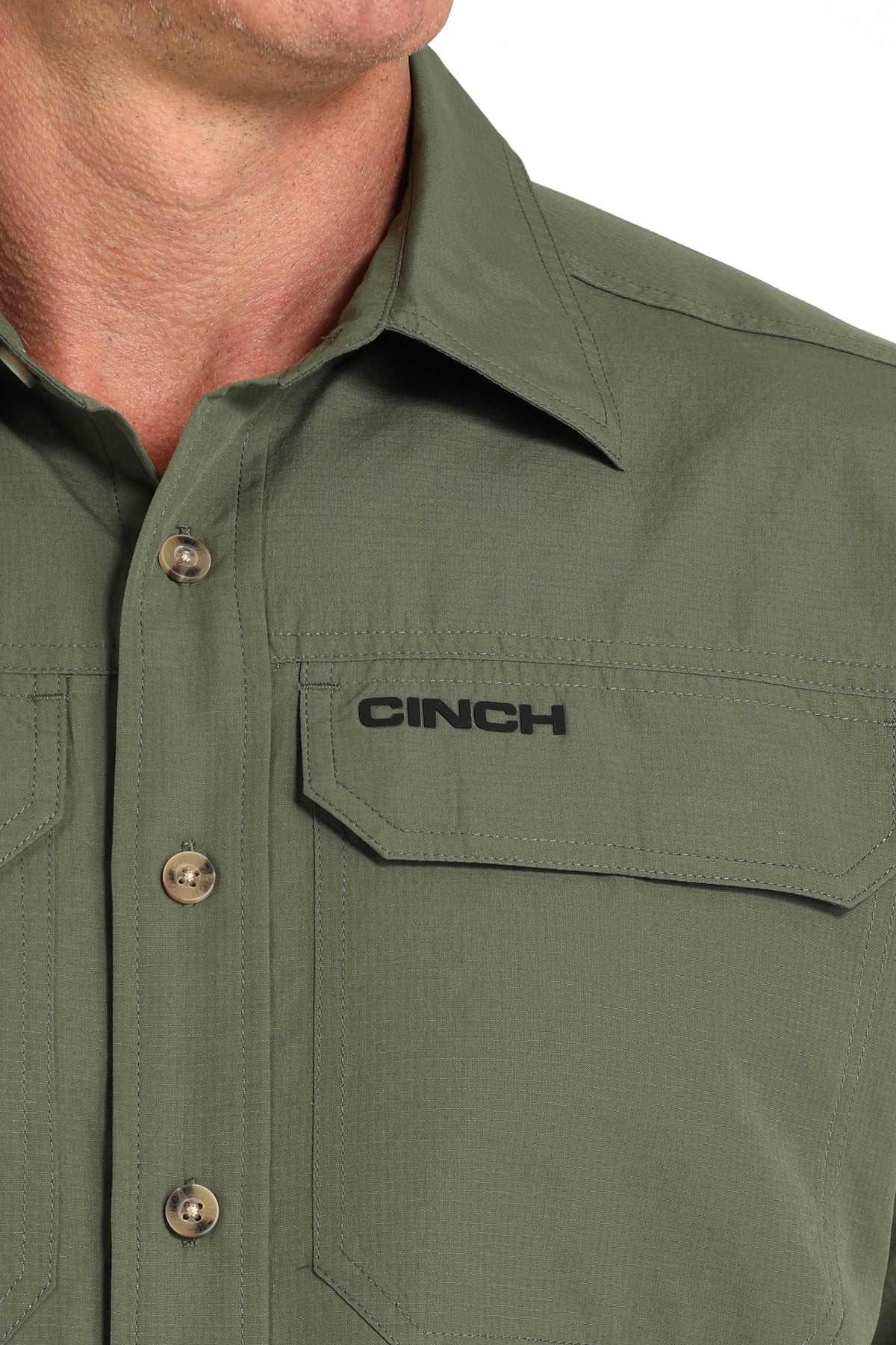 Green shirt with 'CINCH' logo on a close-up of a collar