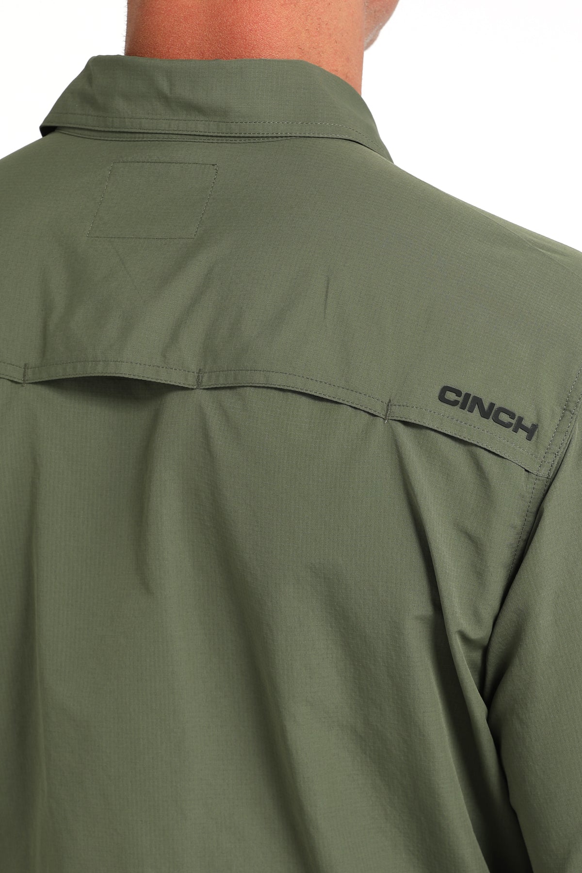 Green shirt with 'CINCH' logo on sleeve against a white background