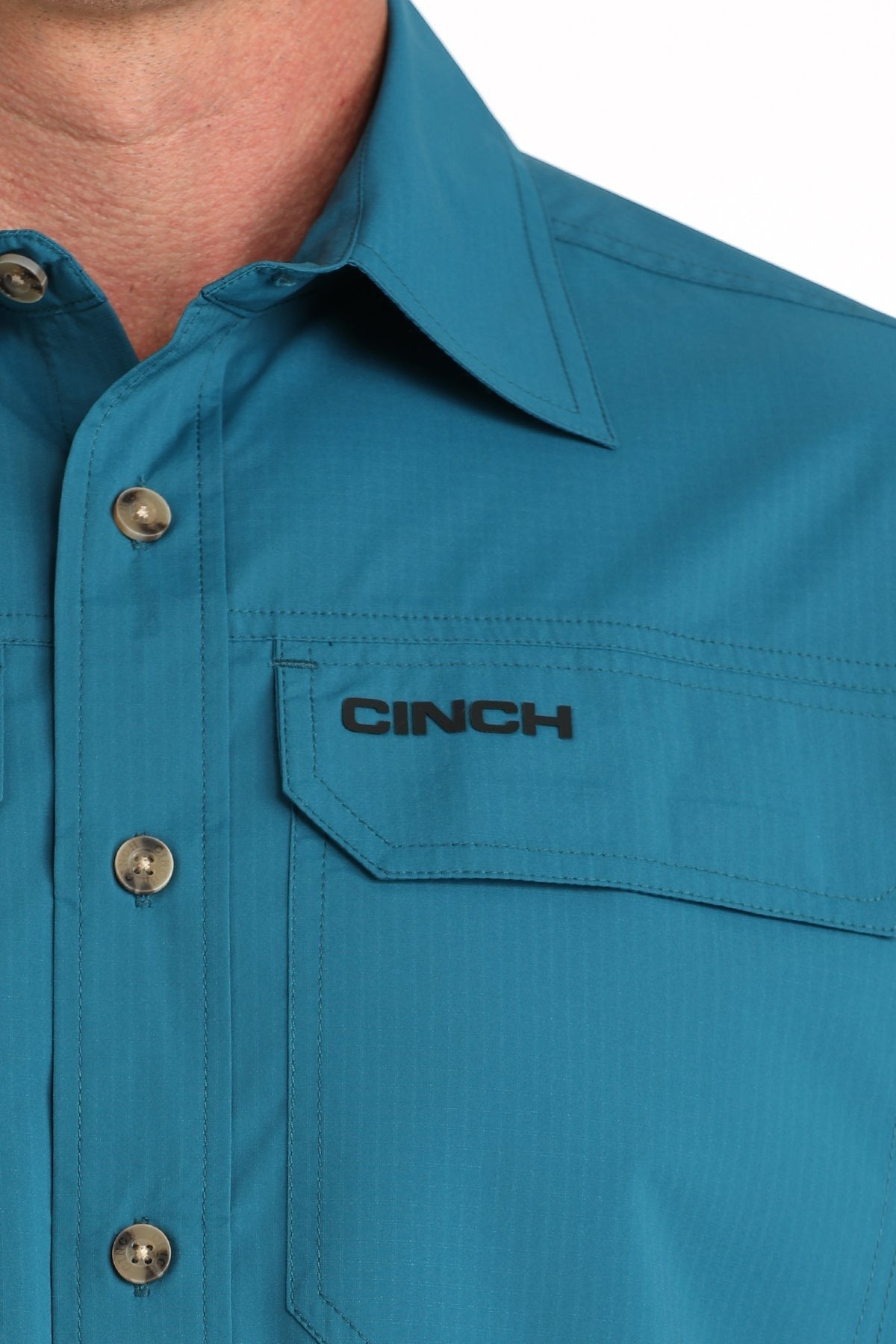 Go West Supply teal long sleeve poly-spandex button-down shirt with embroidered Cinch logo and open pocket.