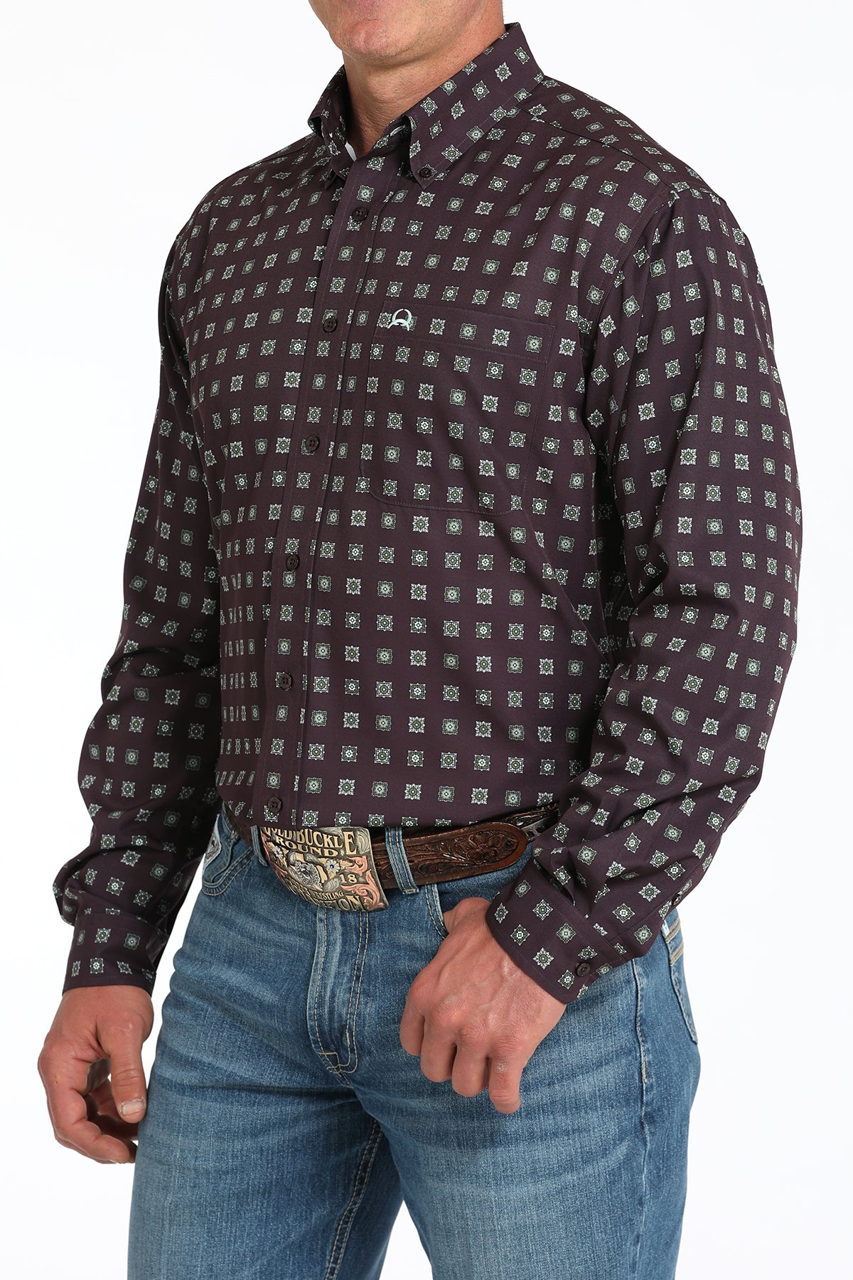 Man wearing a purple long sleeve button-down shirt with jeans and a belt