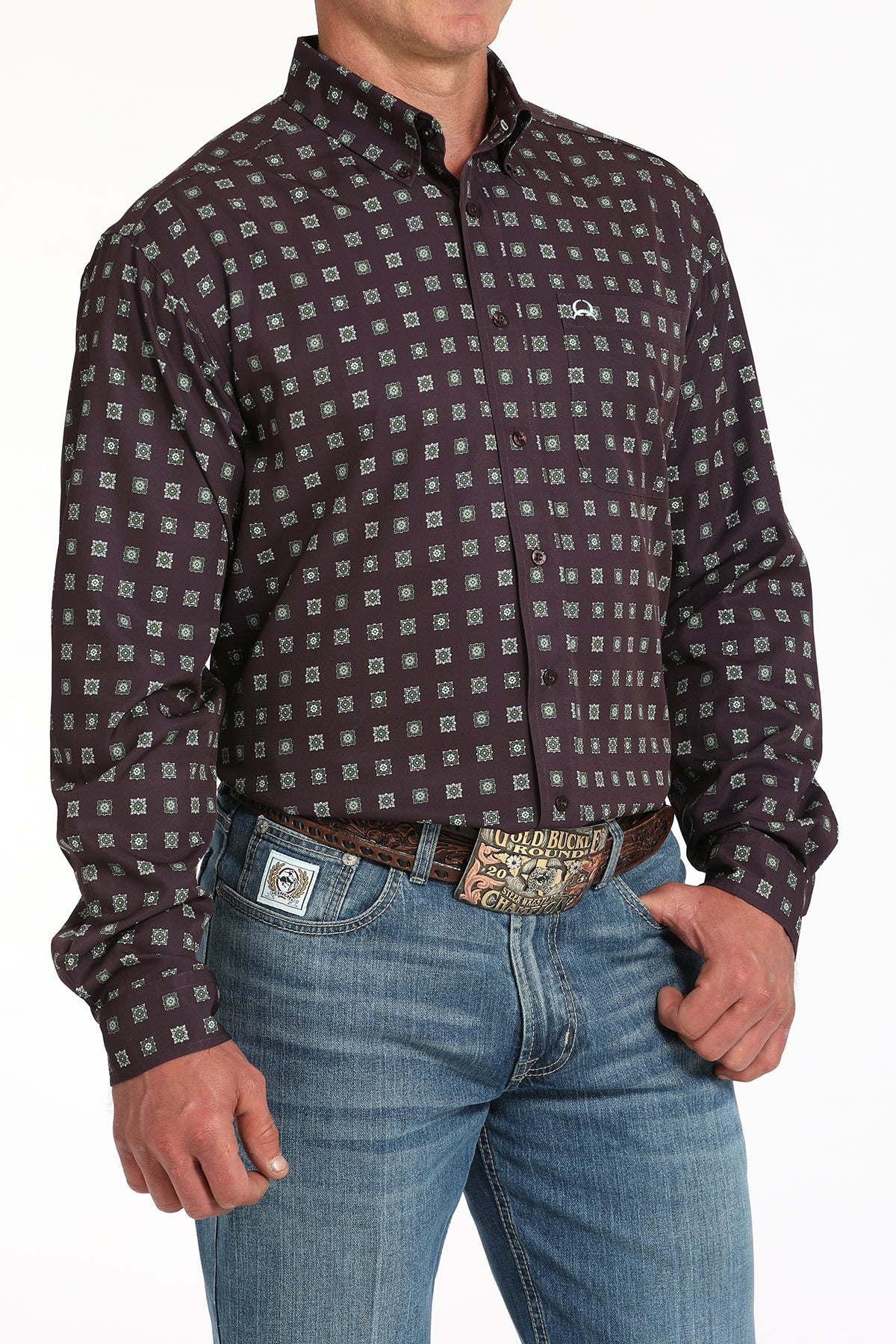 Man wearing a purple long sleeve button-down shirt with jeans and a belt
