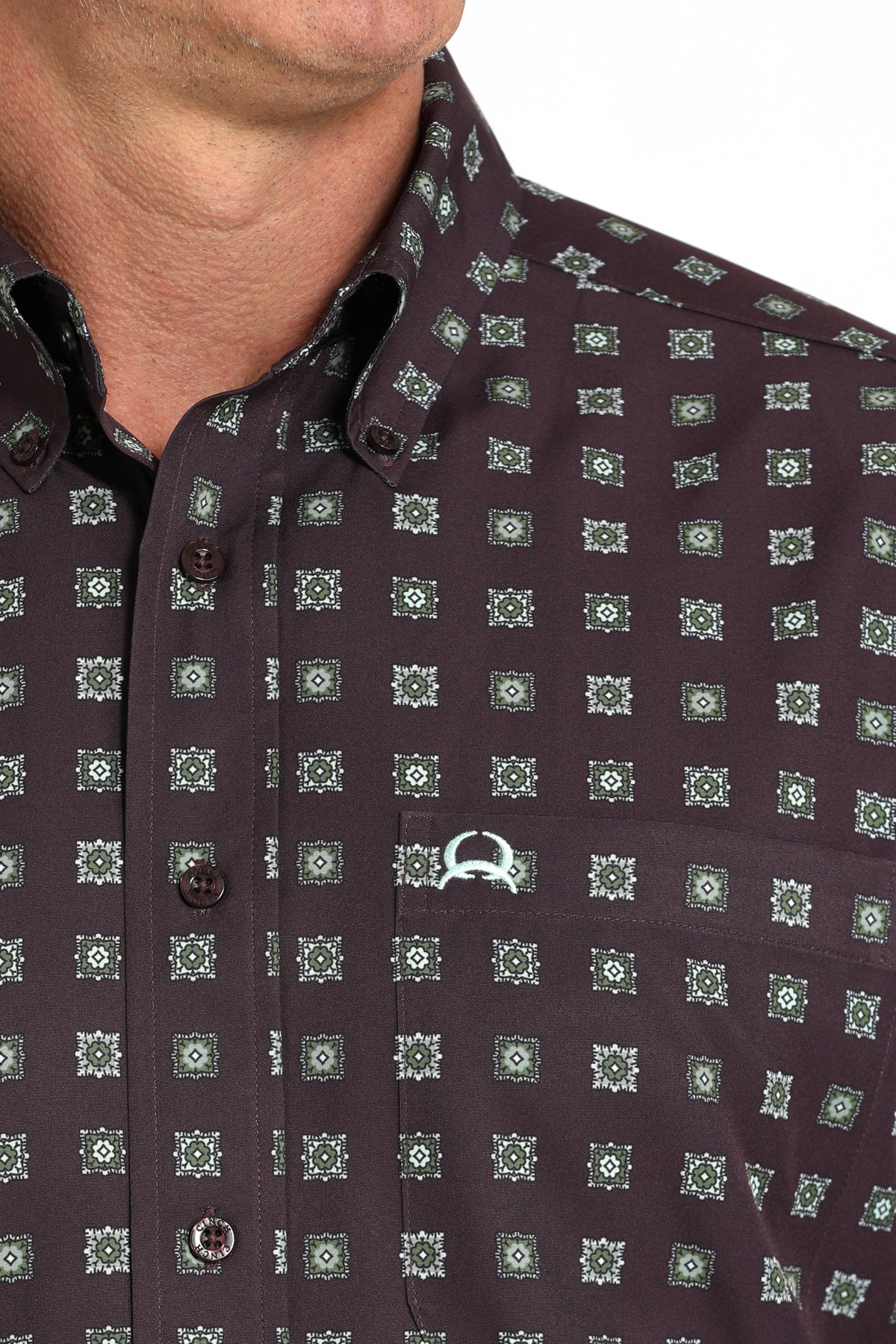 Close- up of a man wearing a purple long sleeve button-down shirt