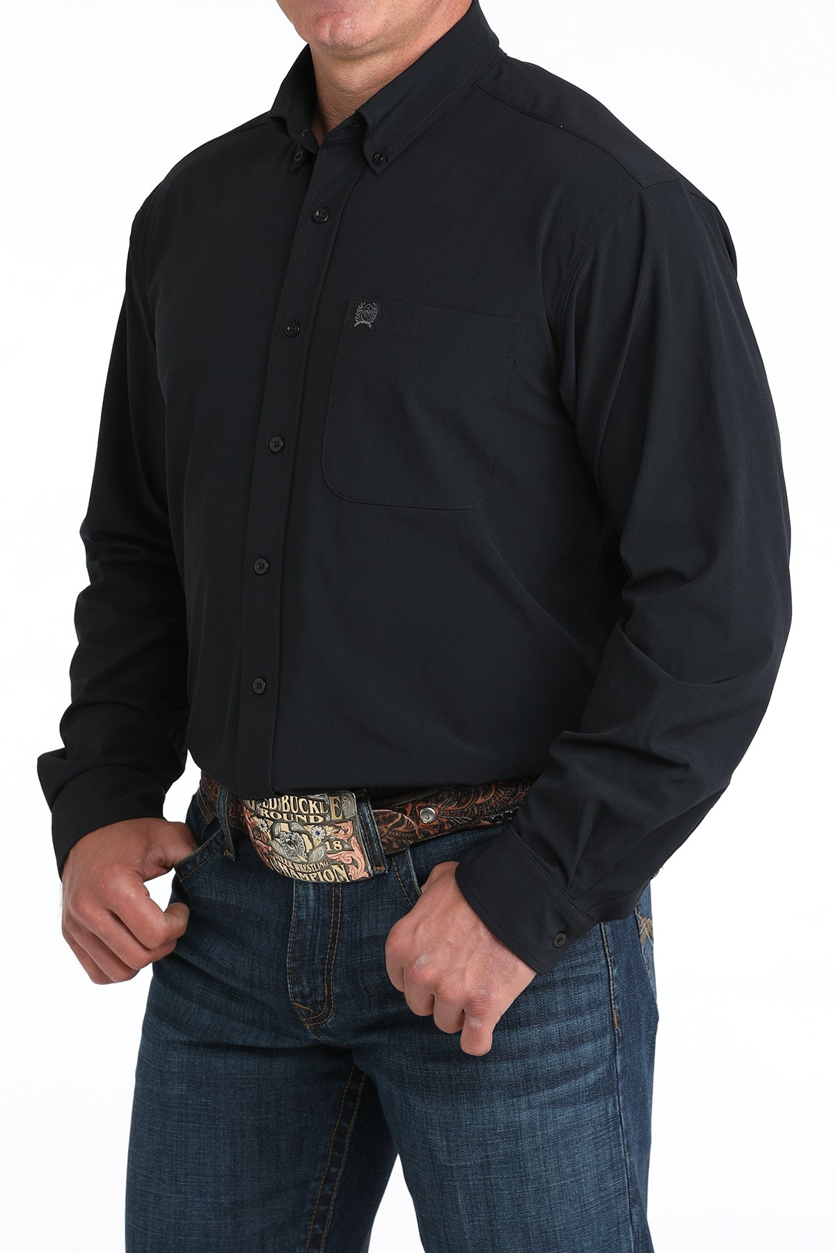 Person wearing a black button-up shirt and jeans with a patterned belt on a white background