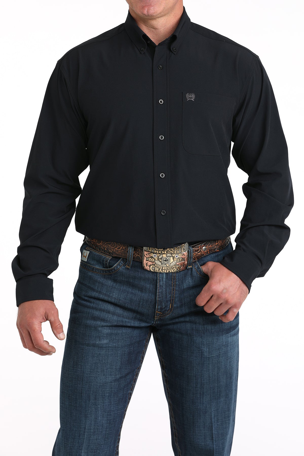 Man wearing a black button-up shirt and blue jeans with a patterned belt on a white background