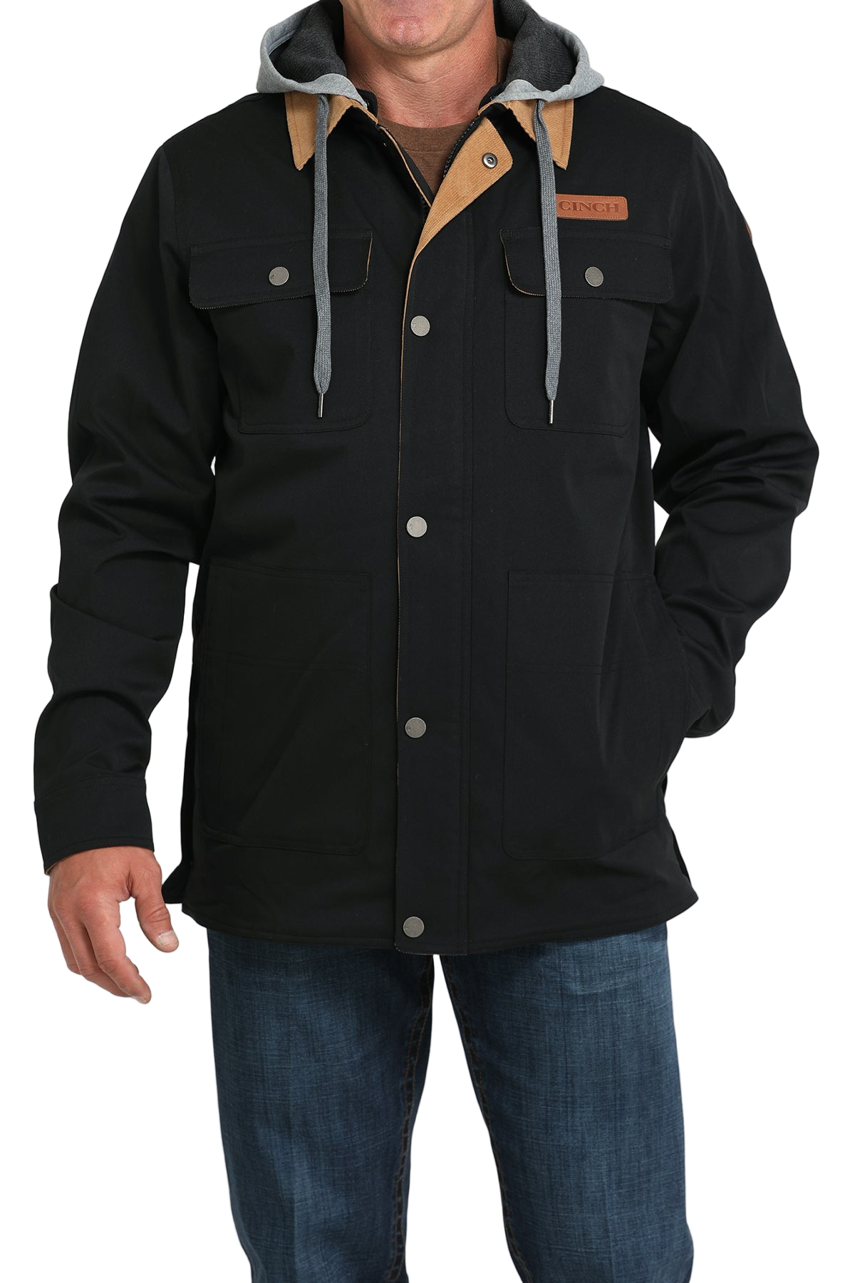 Man wearing a black jacket with a tan collar and attached gray hood, paired with blue jeans