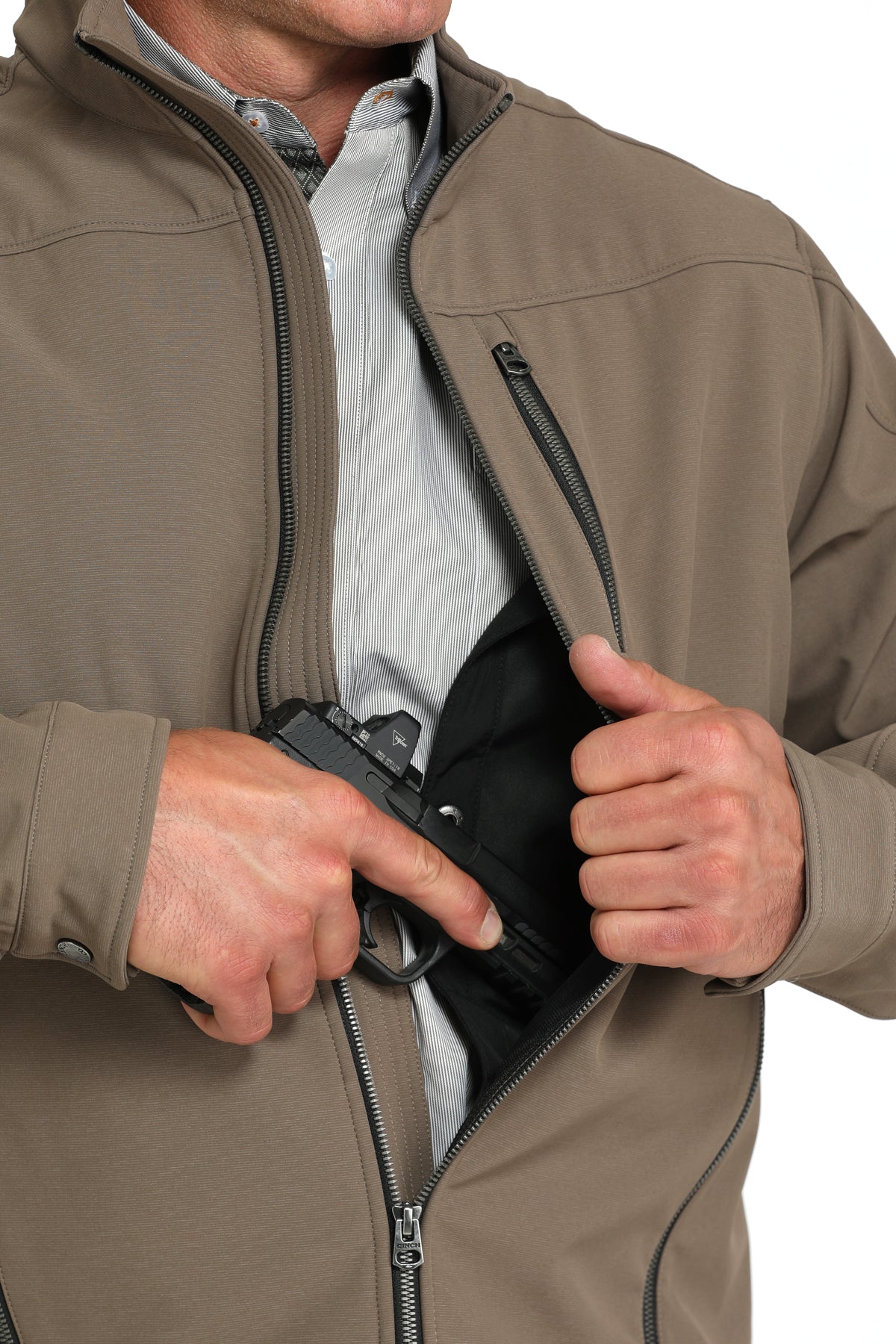 Close-up of a man wearing a brown jacket showing a partial firearm going into the concealed carry pocket