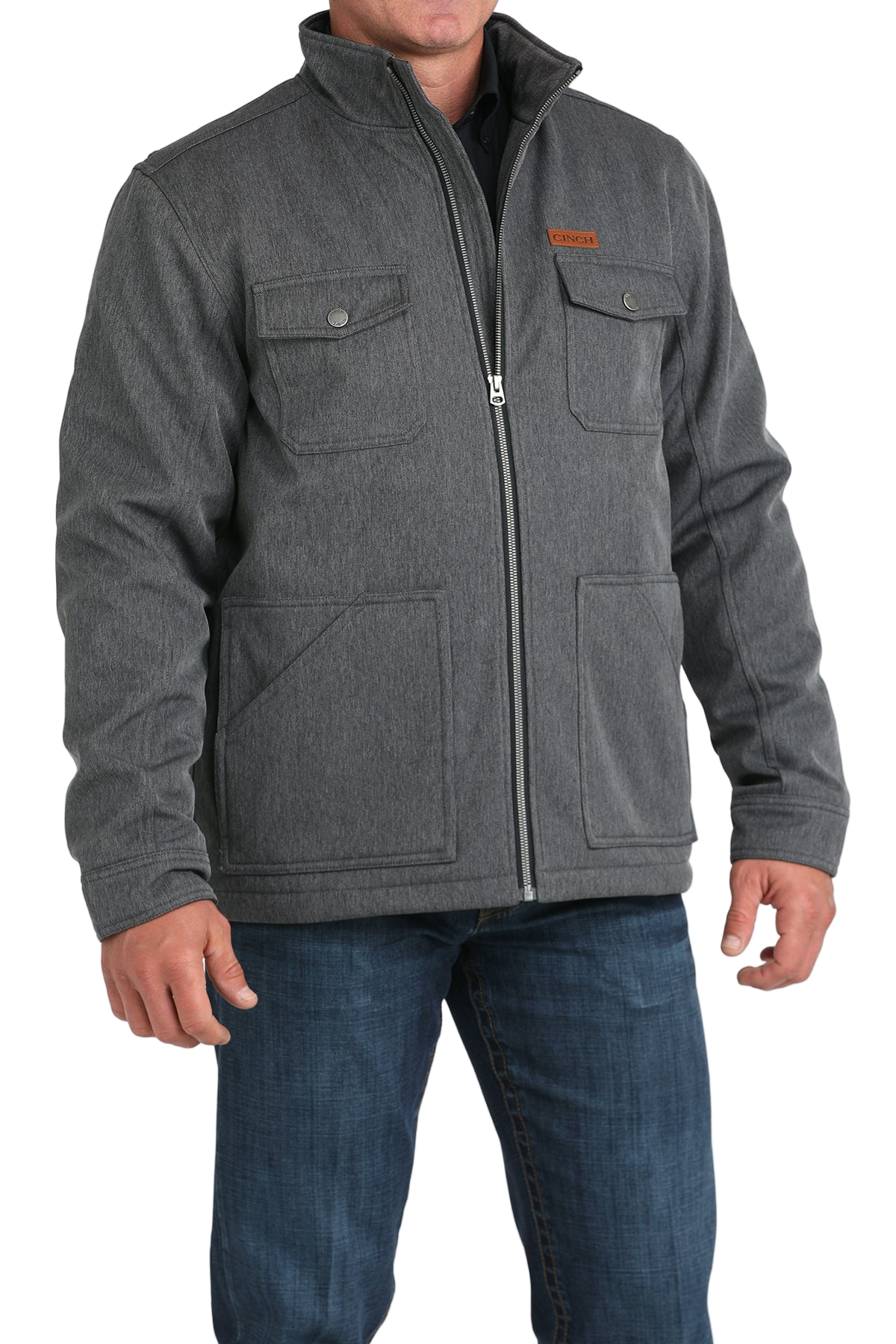 Man wearing a gray zip-front jacket, paired with dark jeans