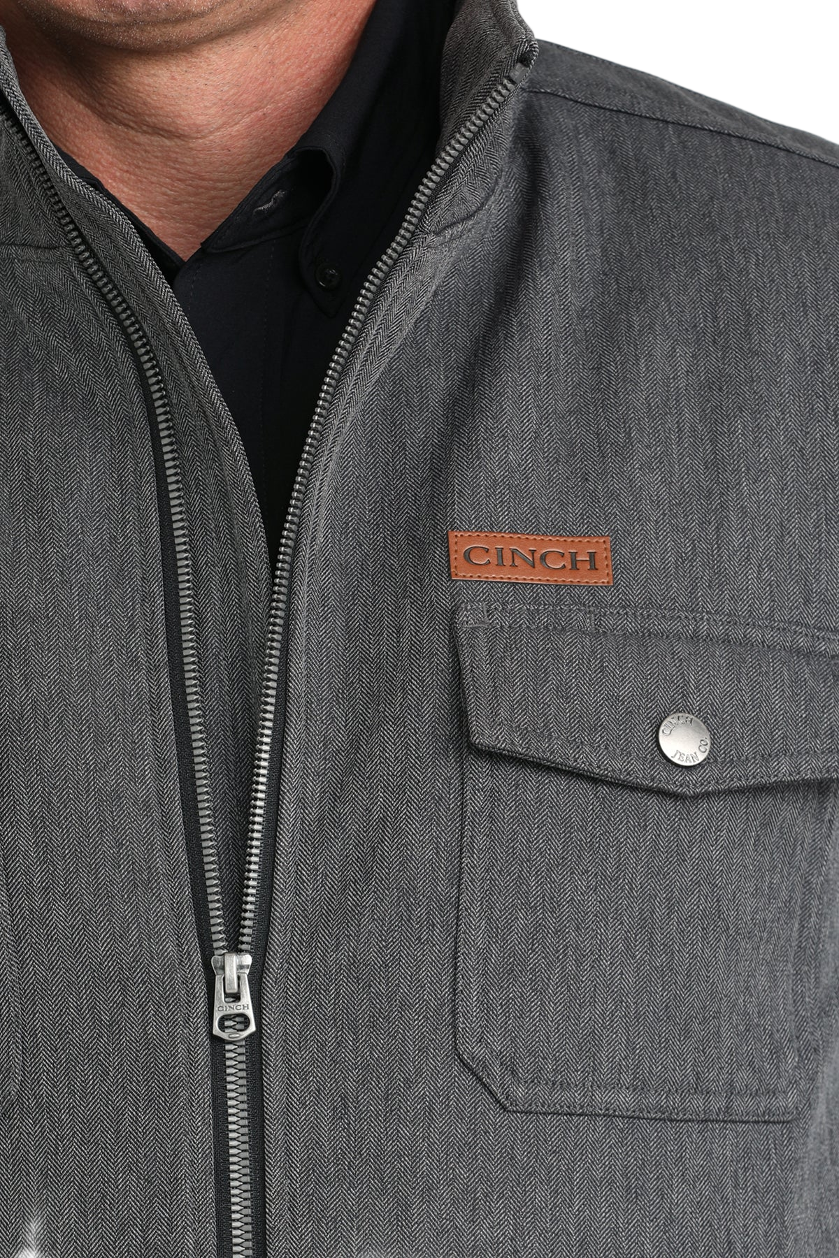 Close-up of a man wearing a gray zip-front jacket