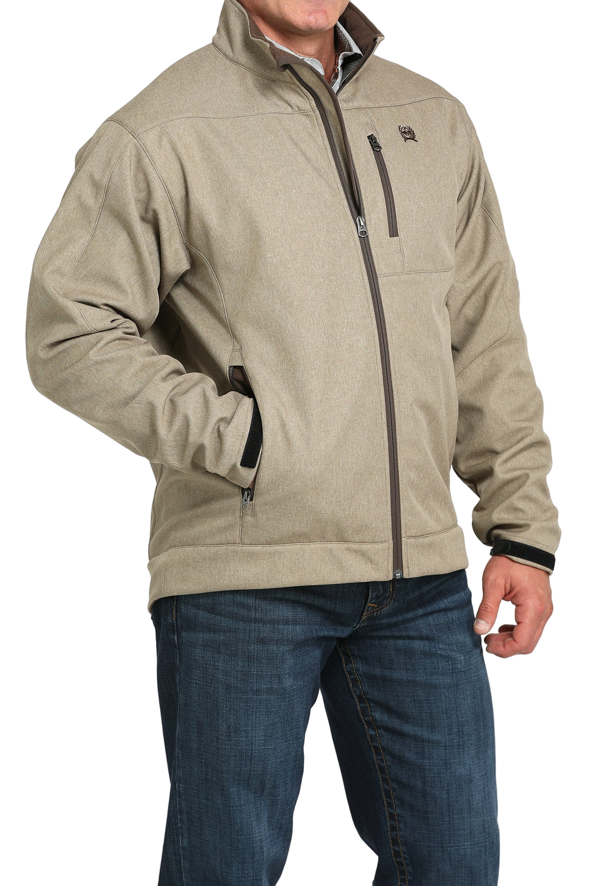 Man wearing a tan zip-front jacket, paired with dark jeans