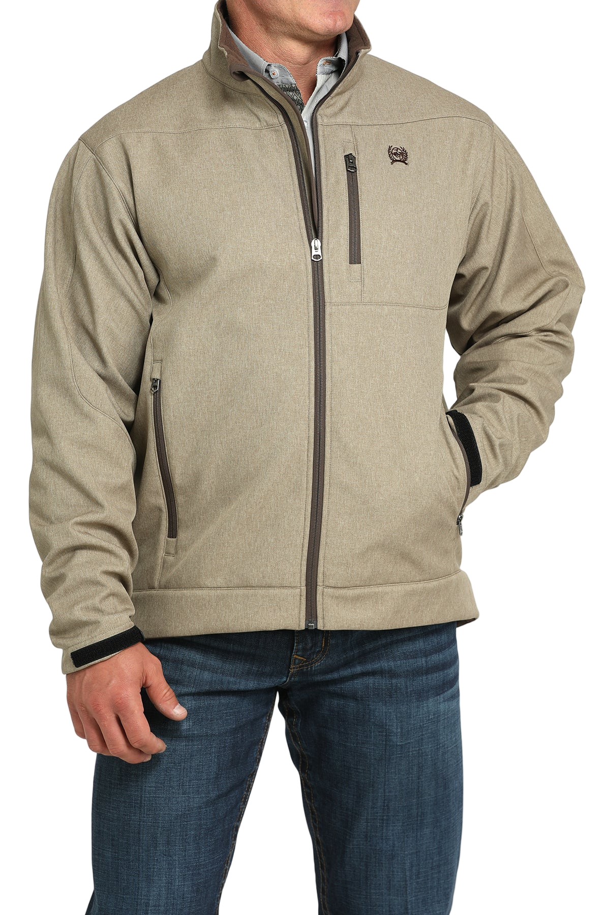 Man wearing a tan zip-front jacket, paired with dark jeans