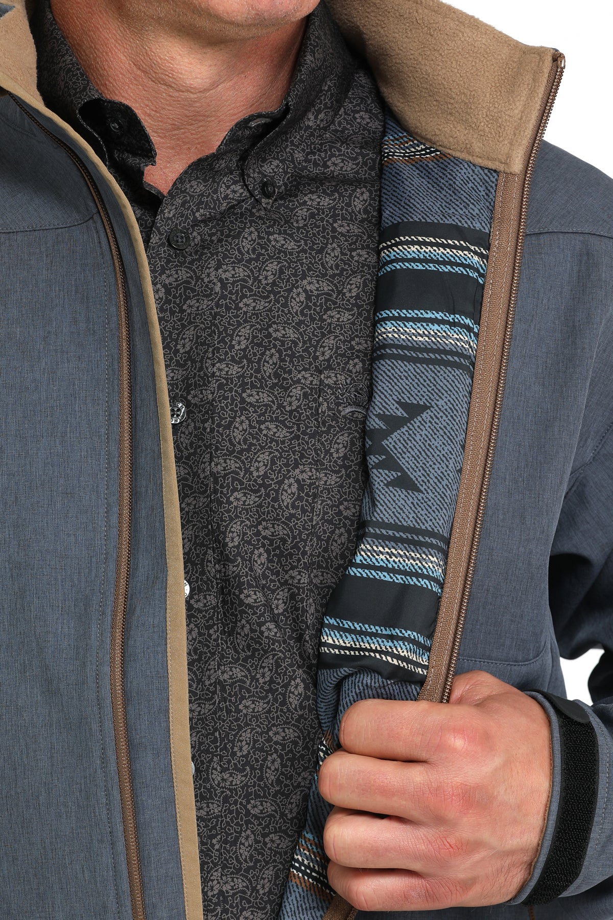 Close-up of a man wearing a blue jacket displaying the interior pattern that the inside has