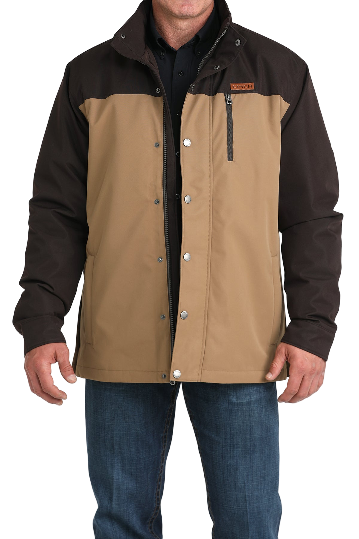 Man wearing a two-tone brown hooded jacket paired with blue jeans