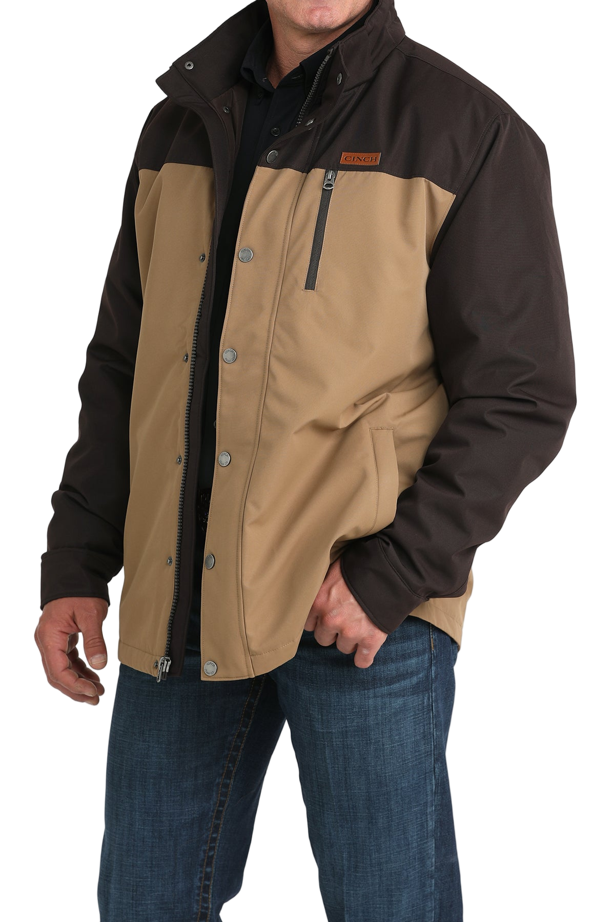 Man wearing a two-tone brown hooded jacket paired with blue jeans