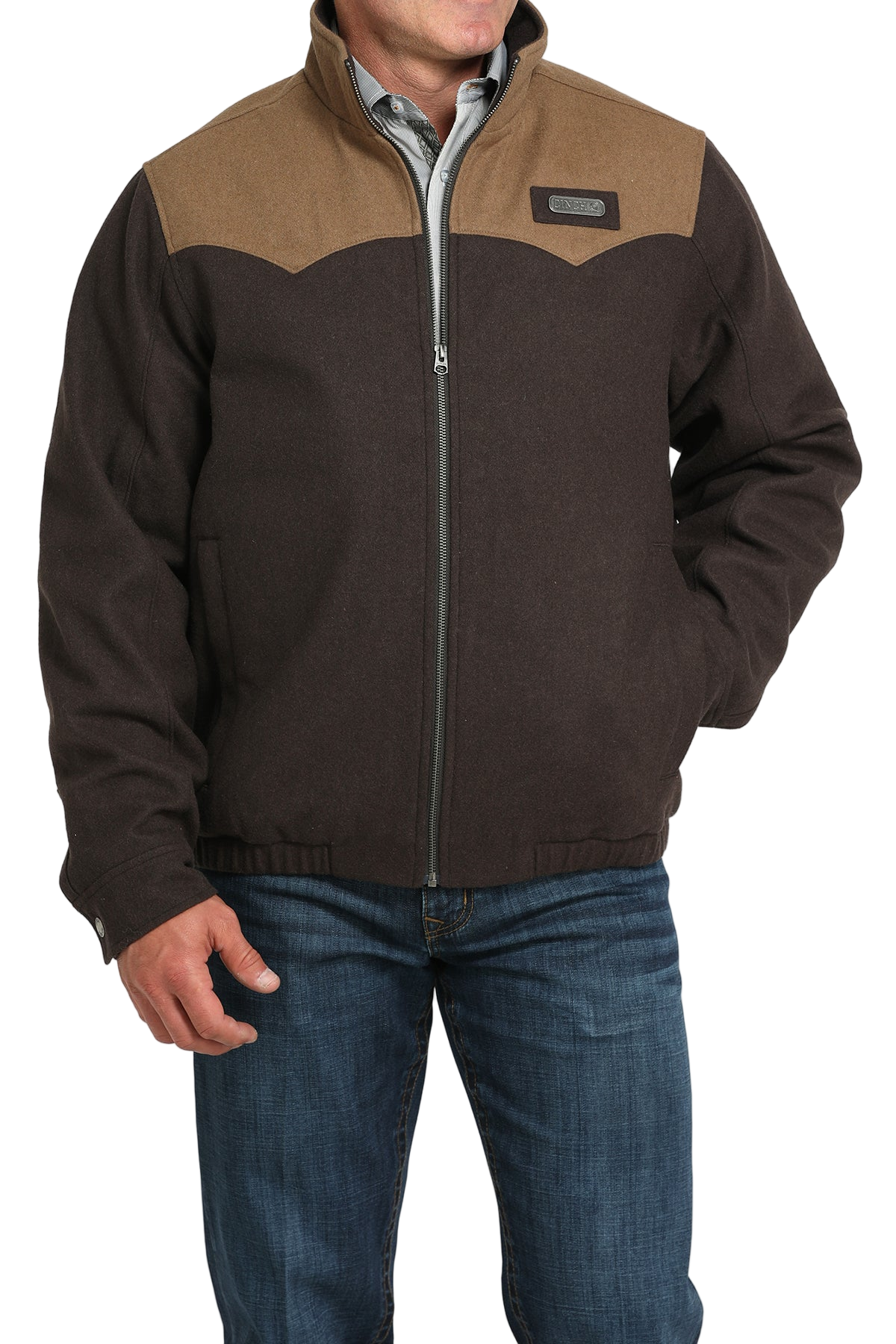 Man wearing a brown zip-up jacket with a lighter brown yoke detail, paired with blue jeans