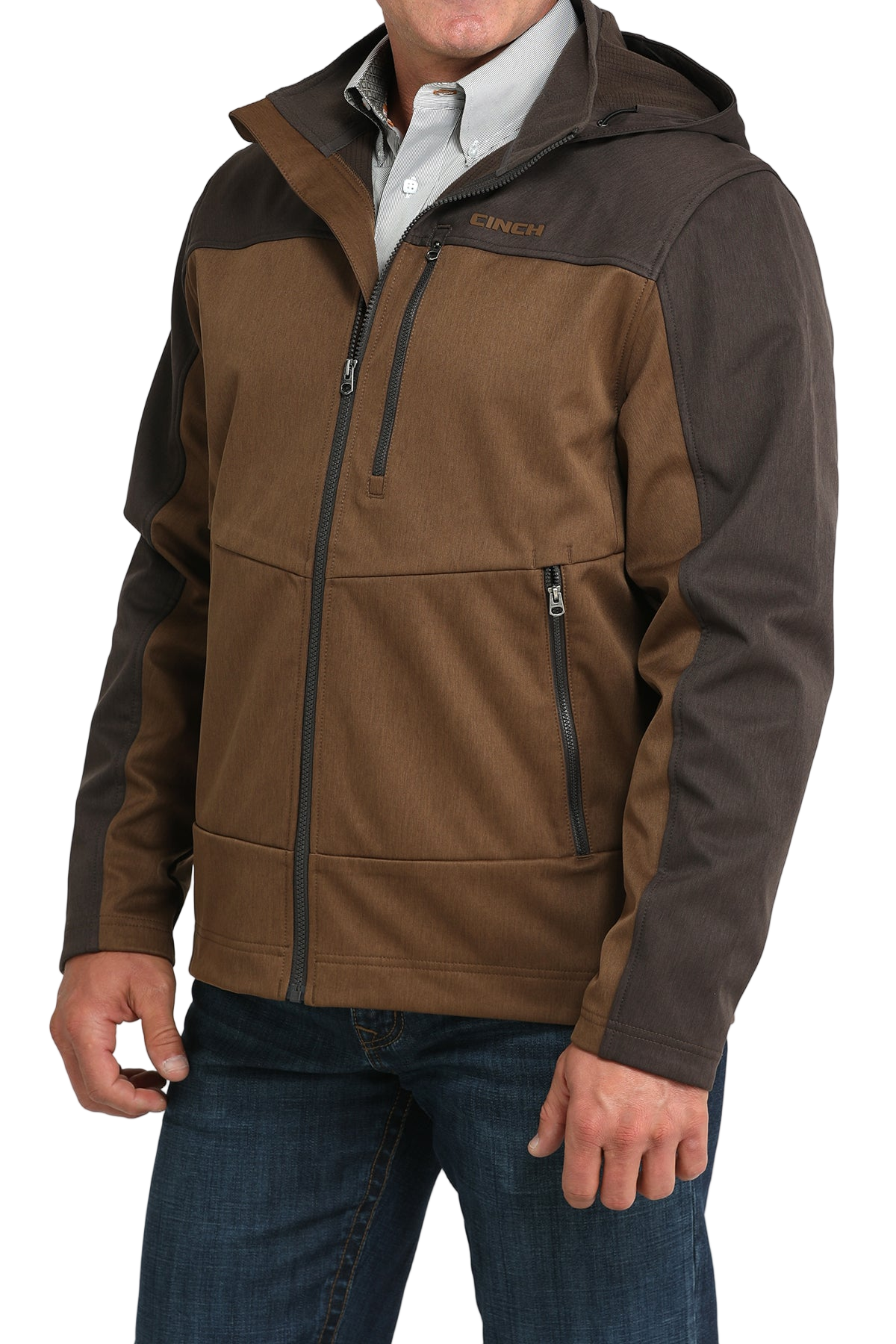 Man wearing a two-tone brown hooded softshell jacket paired with blue jeans