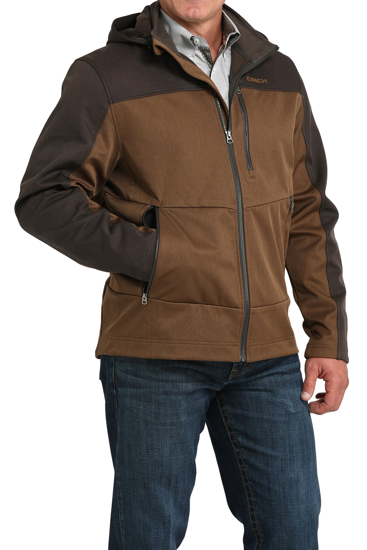 Man wearing a two-tone brown hooded softshell jacket paired with blue jeans